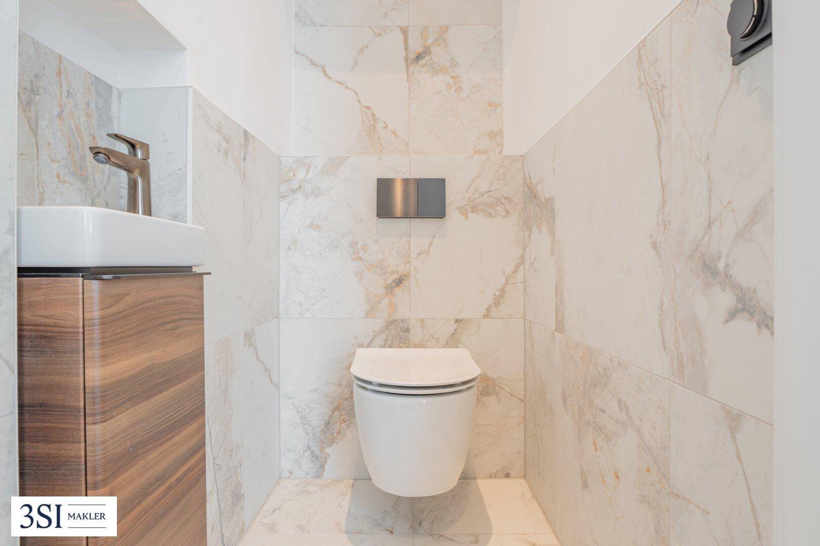 Modernes Gäste-WC mit wandhängender Toilette und eleganten Marmorfliesen.