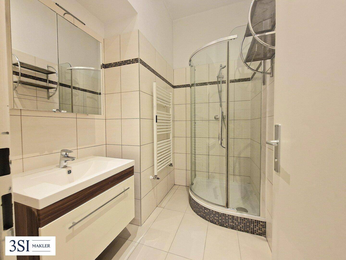 Modernes Badezimmer mit Duschkabine, Waschbecken und Handtuchheizkörper.