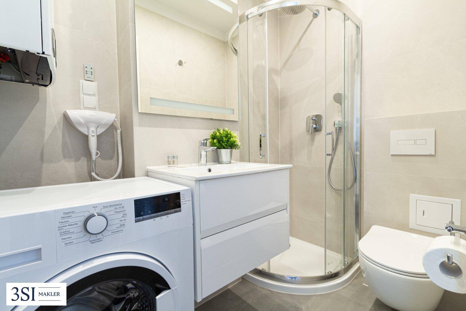 Modernes Badezimmer mit Dusche, Waschbecken, Toilette und Waschmaschine.