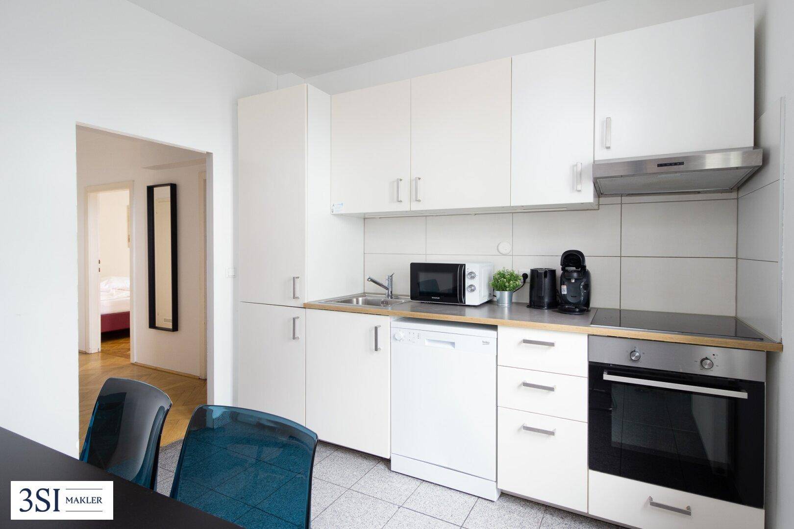 Funktionale weiße Küche mit integriertem Geschirrspüler, Backofen und Kochfeld, ideal für kleine Wohnungen.
