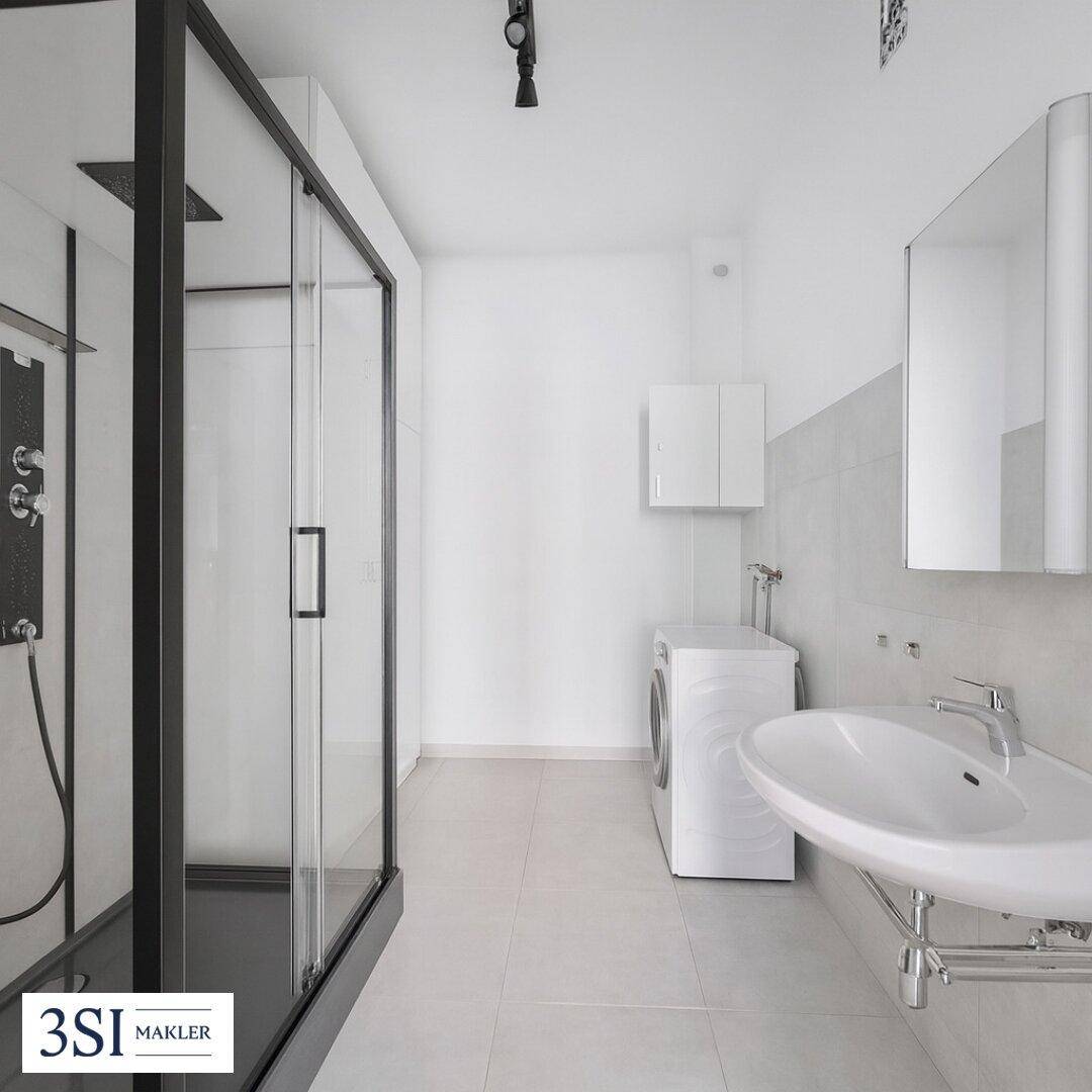 Modernes Badezimmer mit großer Duschkabine, Waschbecken und Waschmaschine.
