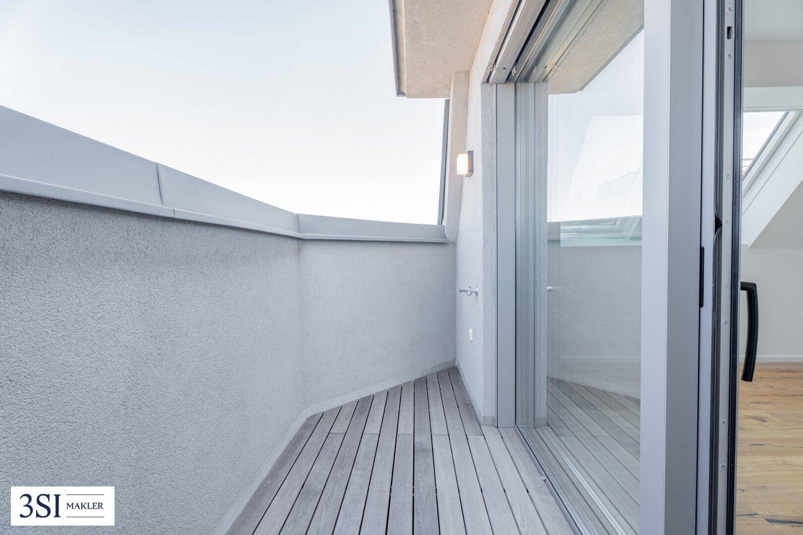 Moderne Dachterrasse mit Holzboden und hoher Brüstung, bietet privaten Außenbereich.