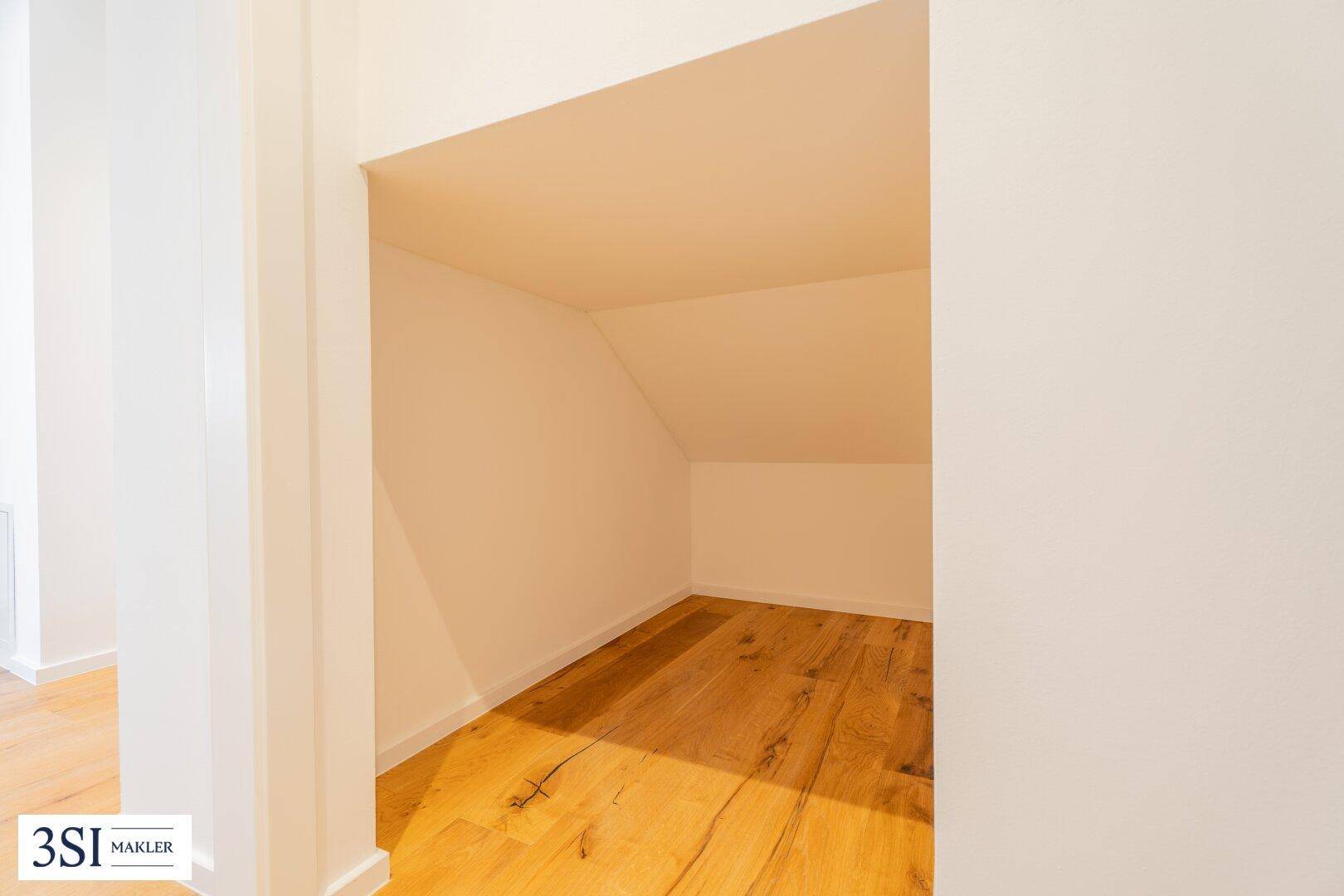 Abstellraum unter der Dachschräge mit Holzboden, bietet zusätzlichen Stauraum.