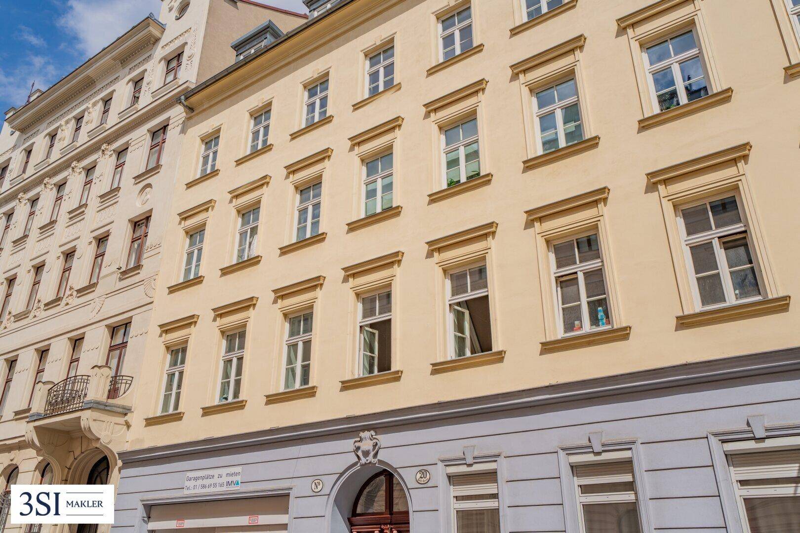 Historische Fassade eines Altbaus mit vielen Fenstern und klassischer Architektur in städtischer Umgebung.