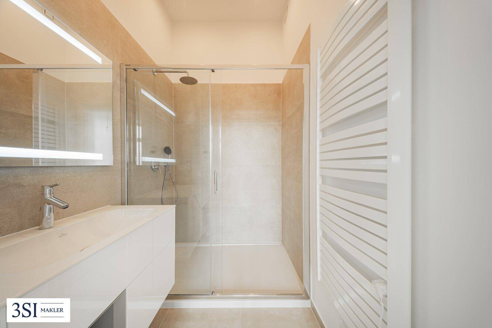 Modernes Badezimmer mit ebenerdiger Dusche, großformatigen Fliesen und beheiztem Handtuchhalter.
