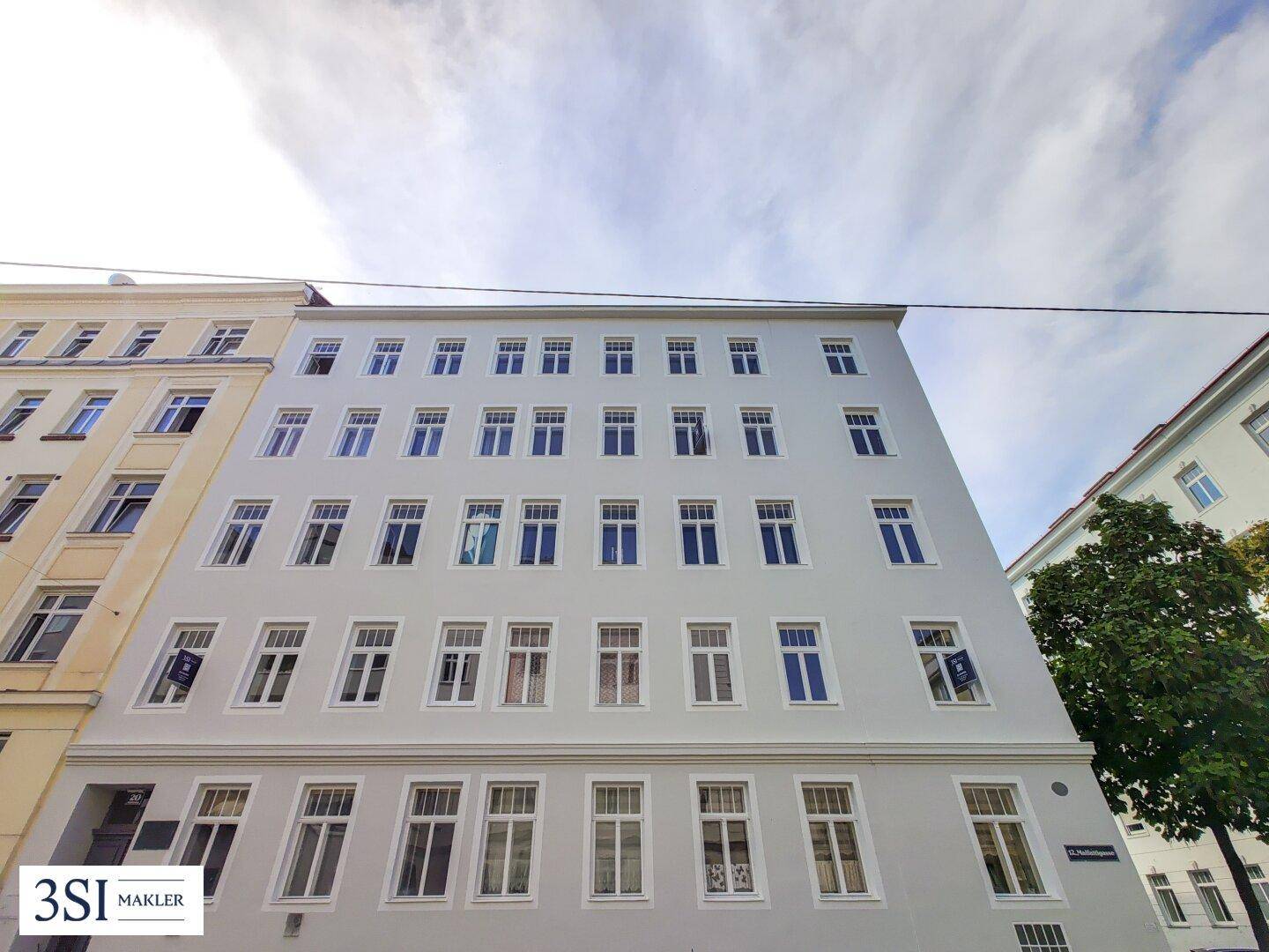 Fassade eines Mehrfamilienhauses mit vielen Fenstern und schlichter, moderner Architektur.