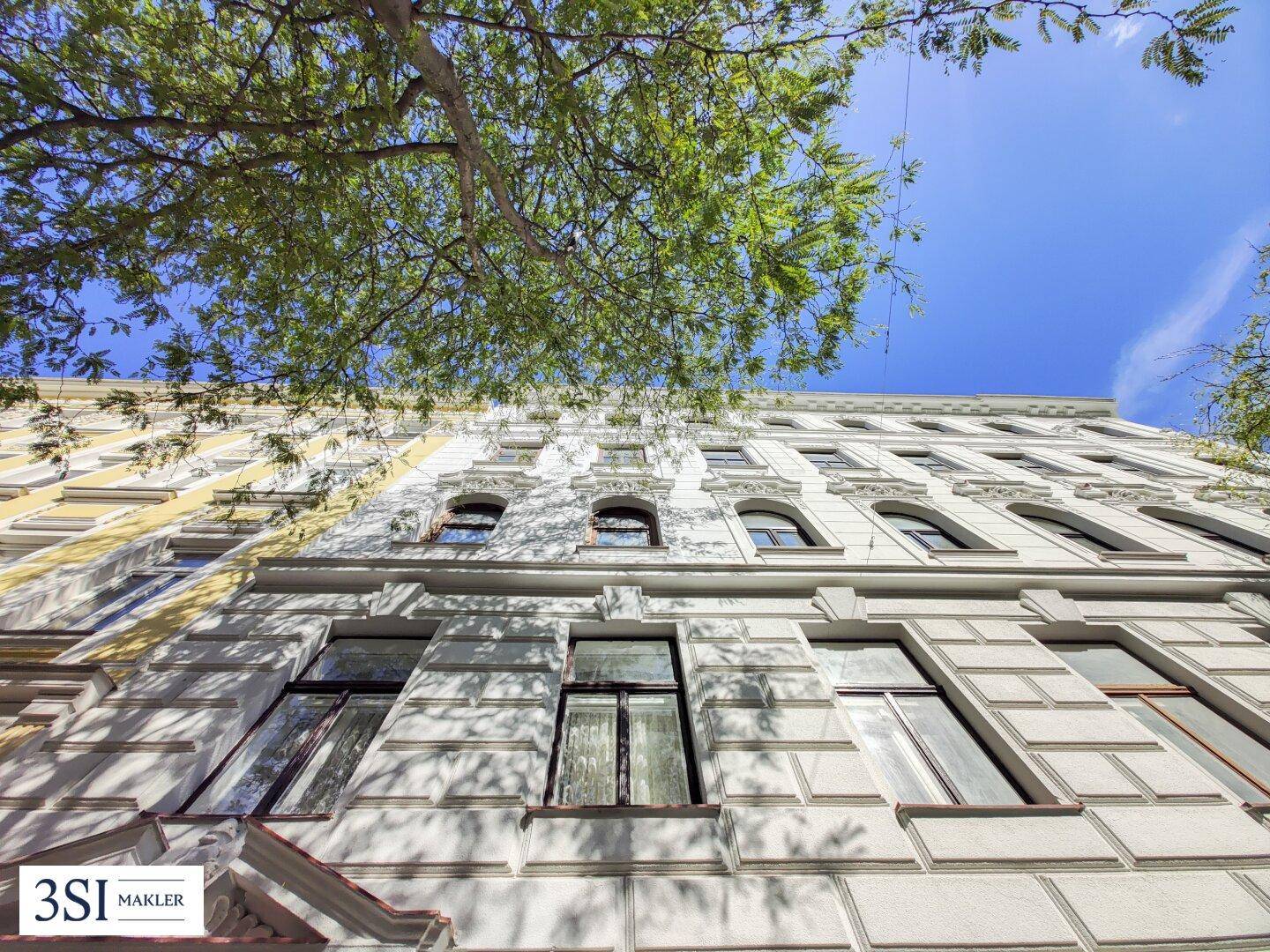 Detailansicht der historischen Fassade mit verzierten Fenstern und Stuckelementen.