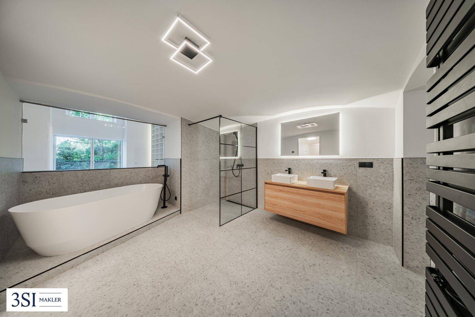 Modernes Badezimmer mit freistehender Badewanne, Doppelwaschbecken und begehbarer Dusche.