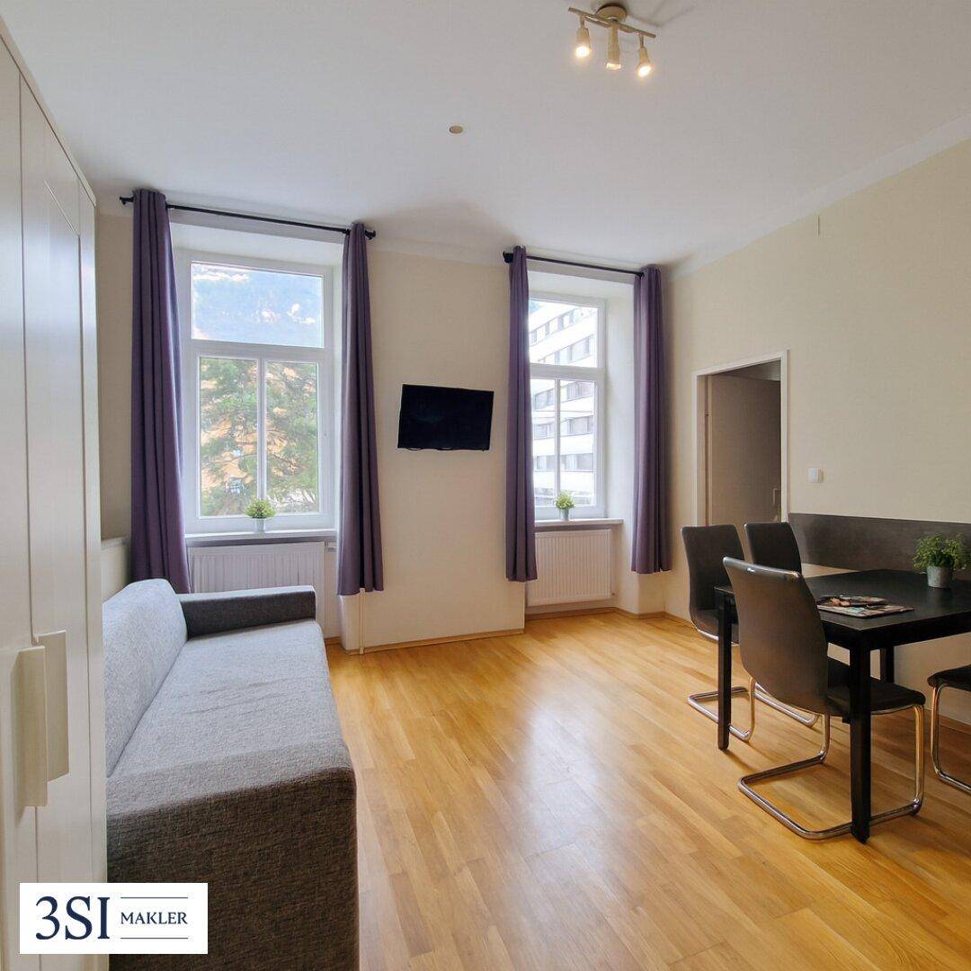 Heller Wohn- und Essbereich mit Holzfußboden, Sofa und Esstisch, ideal für geselliges Beisammensein.