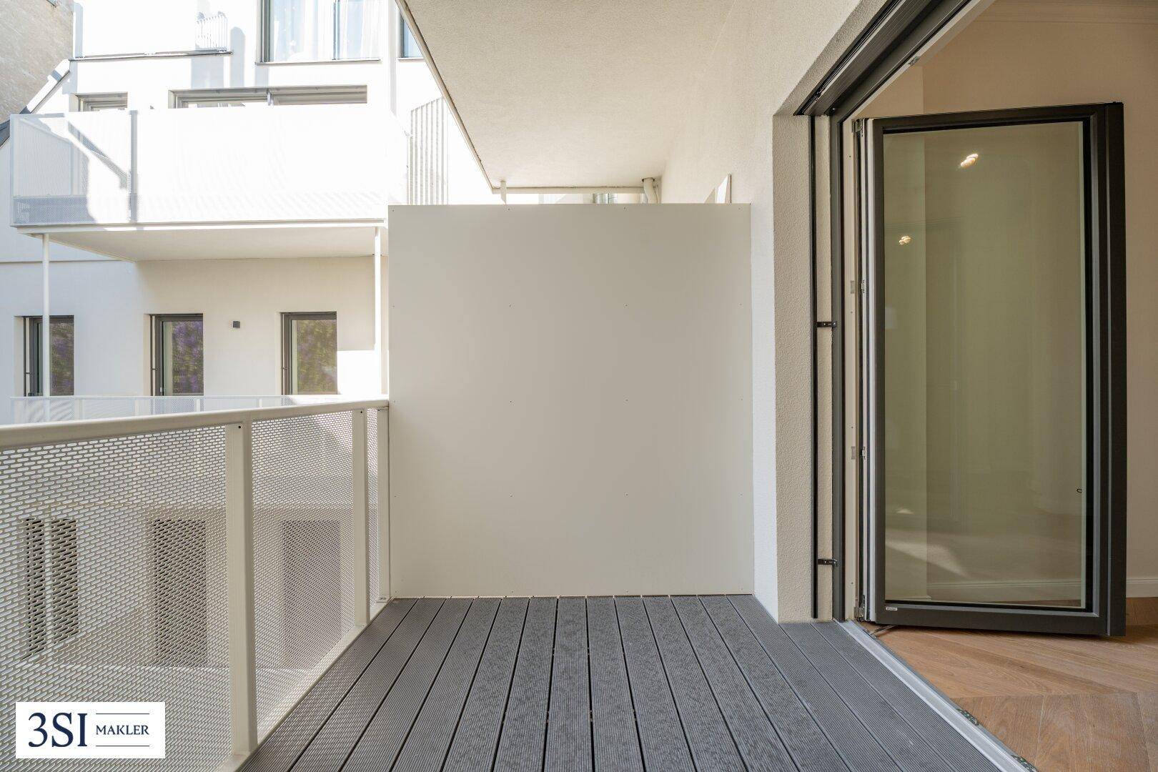 Moderner Balkon mit Holzdielenboden und Blick auf die umliegenden Gebäude.