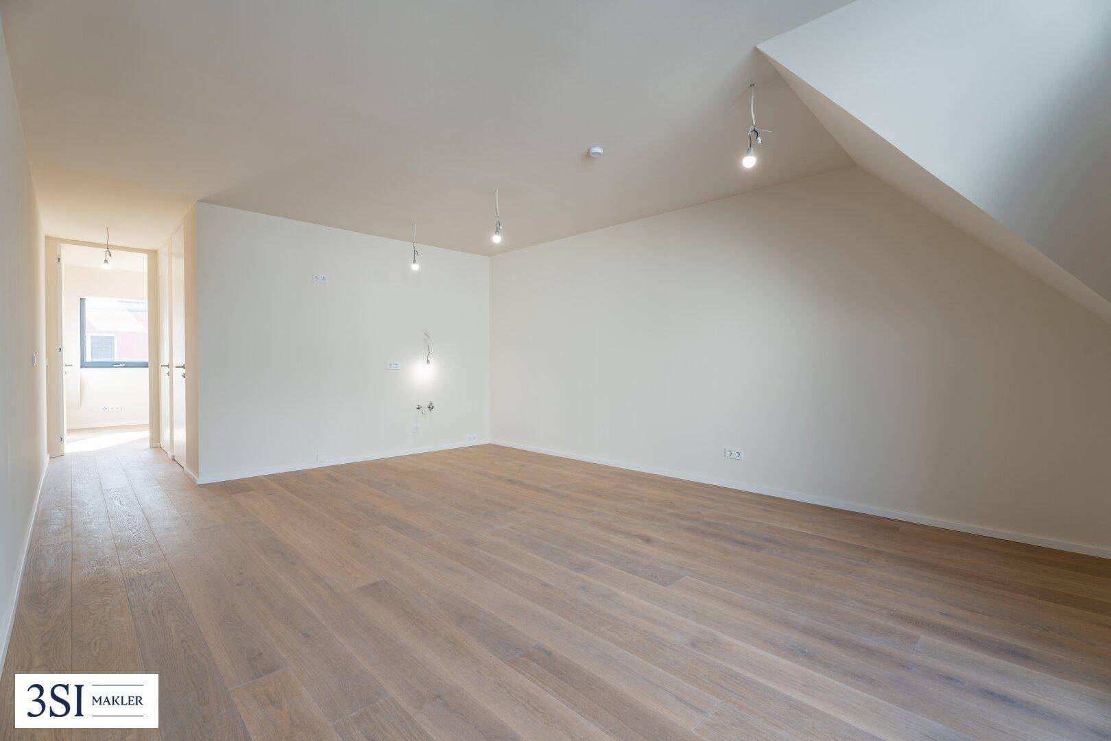 Geräumiger, heller Wohnbereich mit Holzfußboden und Dachschräge, ideal für individuelle Gestaltung.