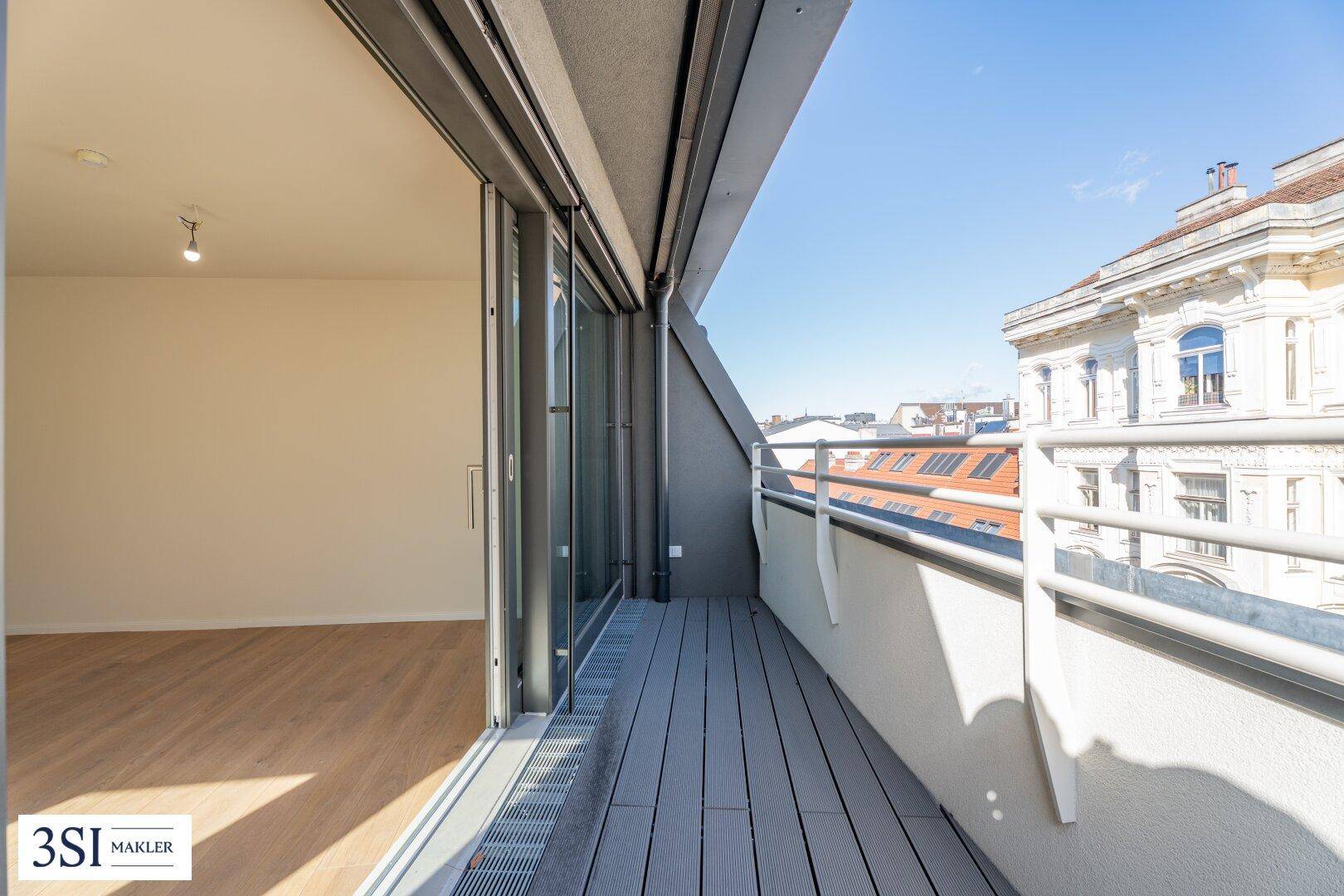 Moderner Balkon mit Holzdielenboden und Blick auf die umliegenden Gebäude.