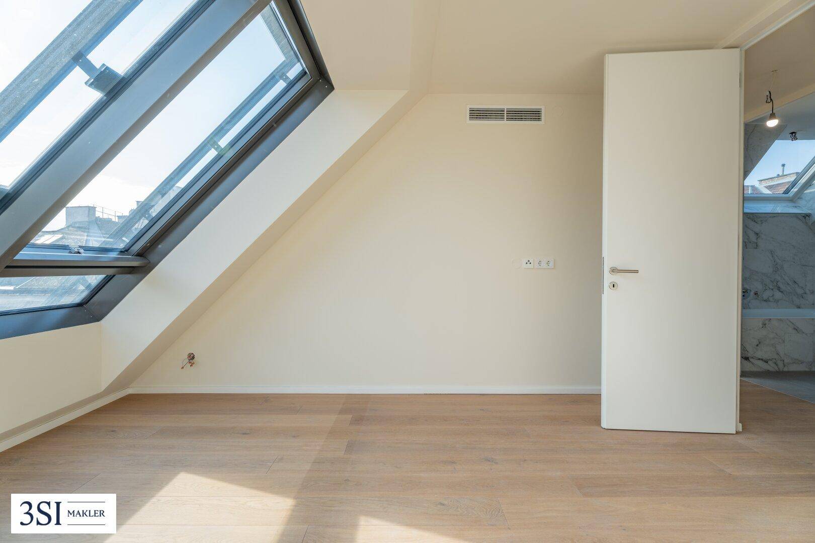 Detailansicht des großen Dachfensters und einer weißen Tür in einem hellen, modernen Dachgeschossraum.
