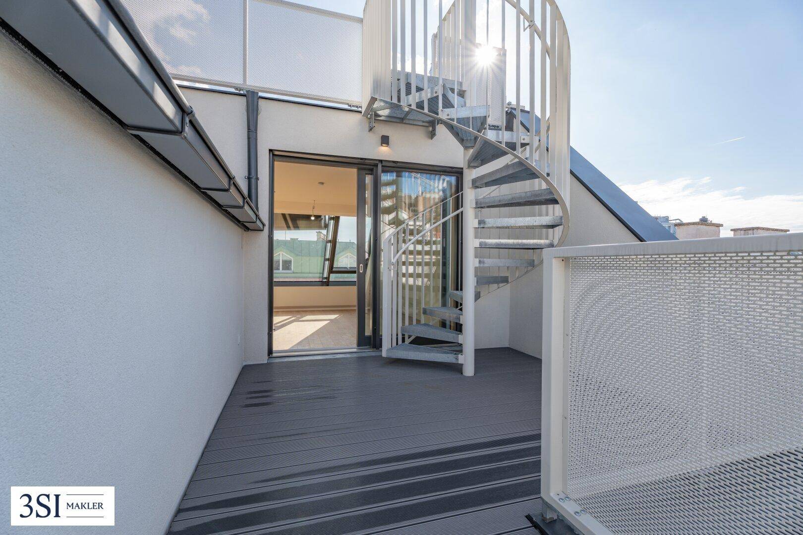 Geräumige Dachterrasse mit modernem Bodenbelag und einer eleganten Wendeltreppe zum oberen Bereich.