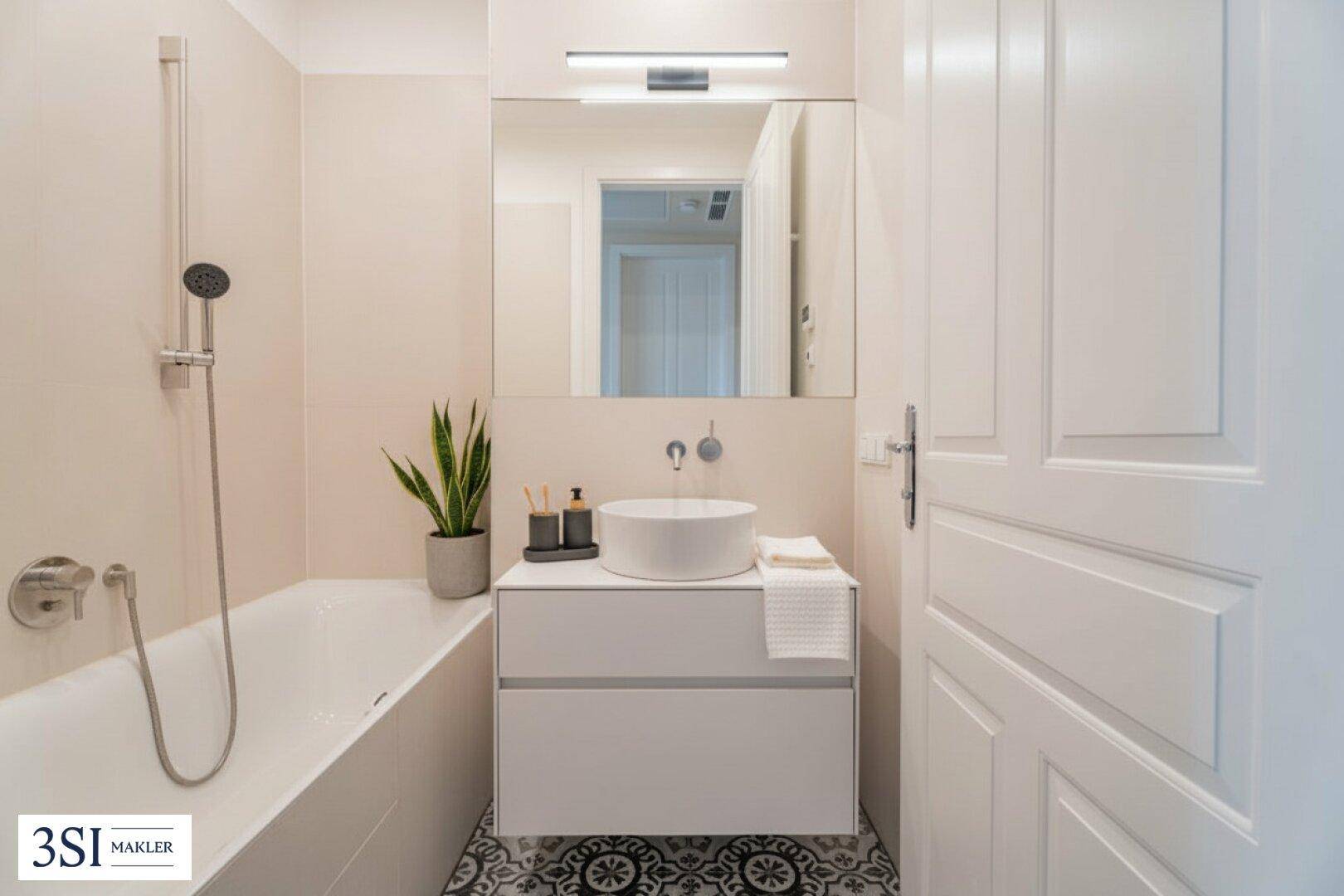 Modernes Badezimmer mit Badewanne, Einzelwaschbecken und dekorativen Bodenfliesen.