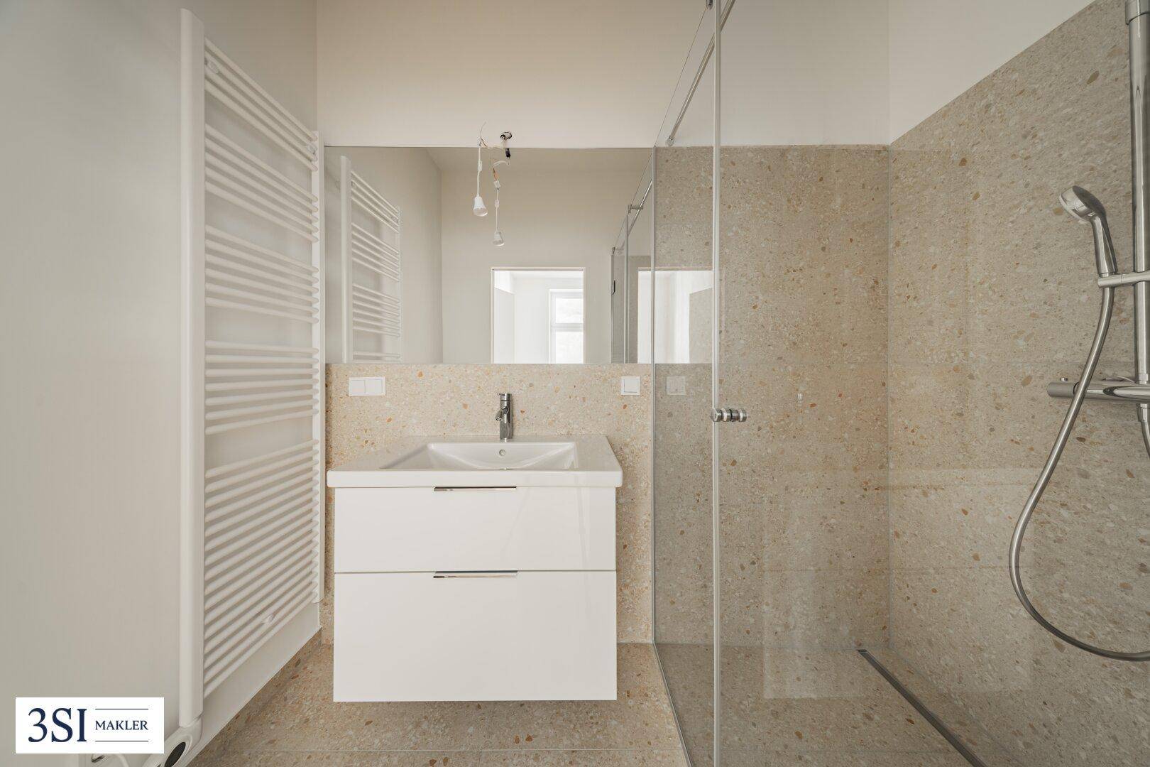 Modernes Badezimmer mit begehbarer Dusche, Einzelwaschbecken und beheiztem Handtuchhalter.