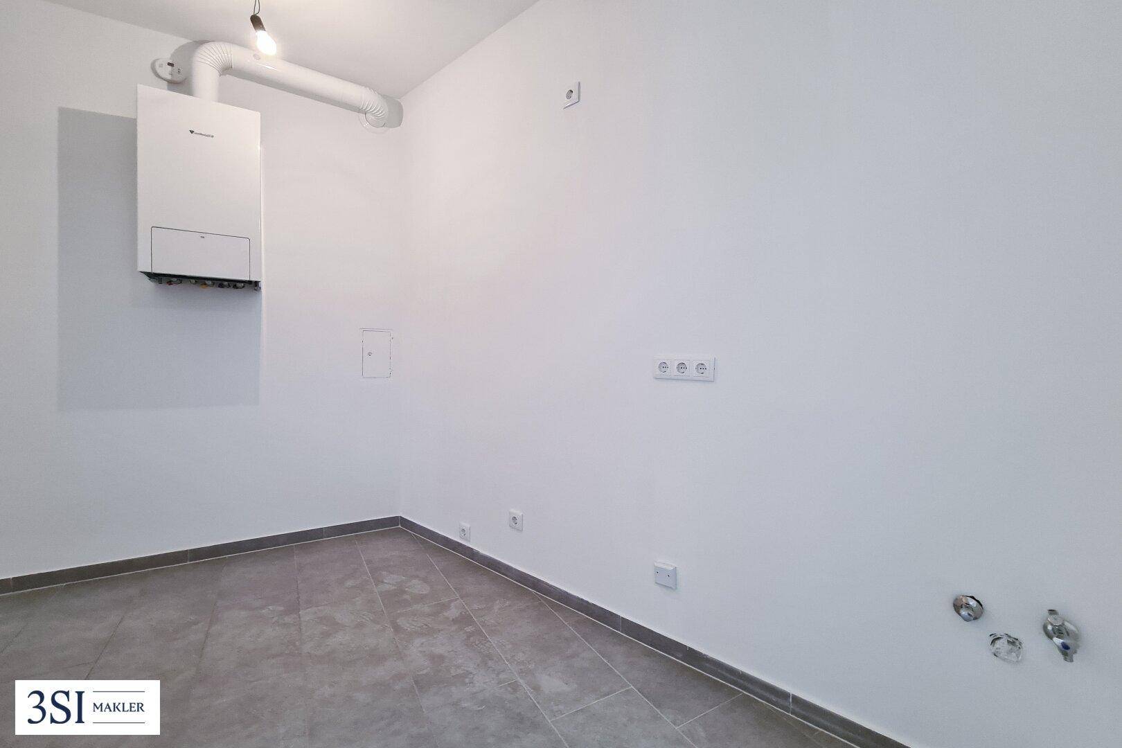 Praktischer Hauswirtschaftsraum mit Gastherme und Anschlüssen für Waschmaschine, funktional und sauber.