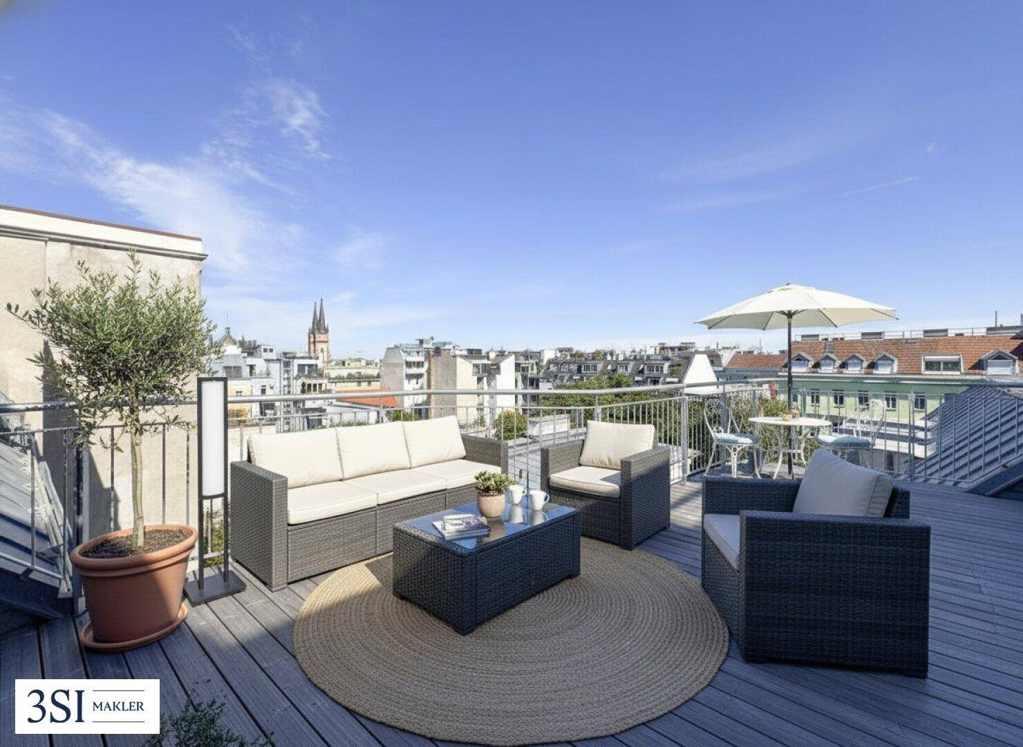 Möblierte Dachterrasse mit Sitzgelegenheiten, Sonnenschirm und weitem Stadtblick.