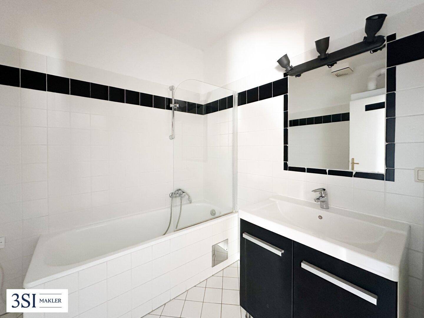 Modernes Badezimmer mit Badewanne, Duschabtrennung und einem Waschbecken mit Unterschrank.