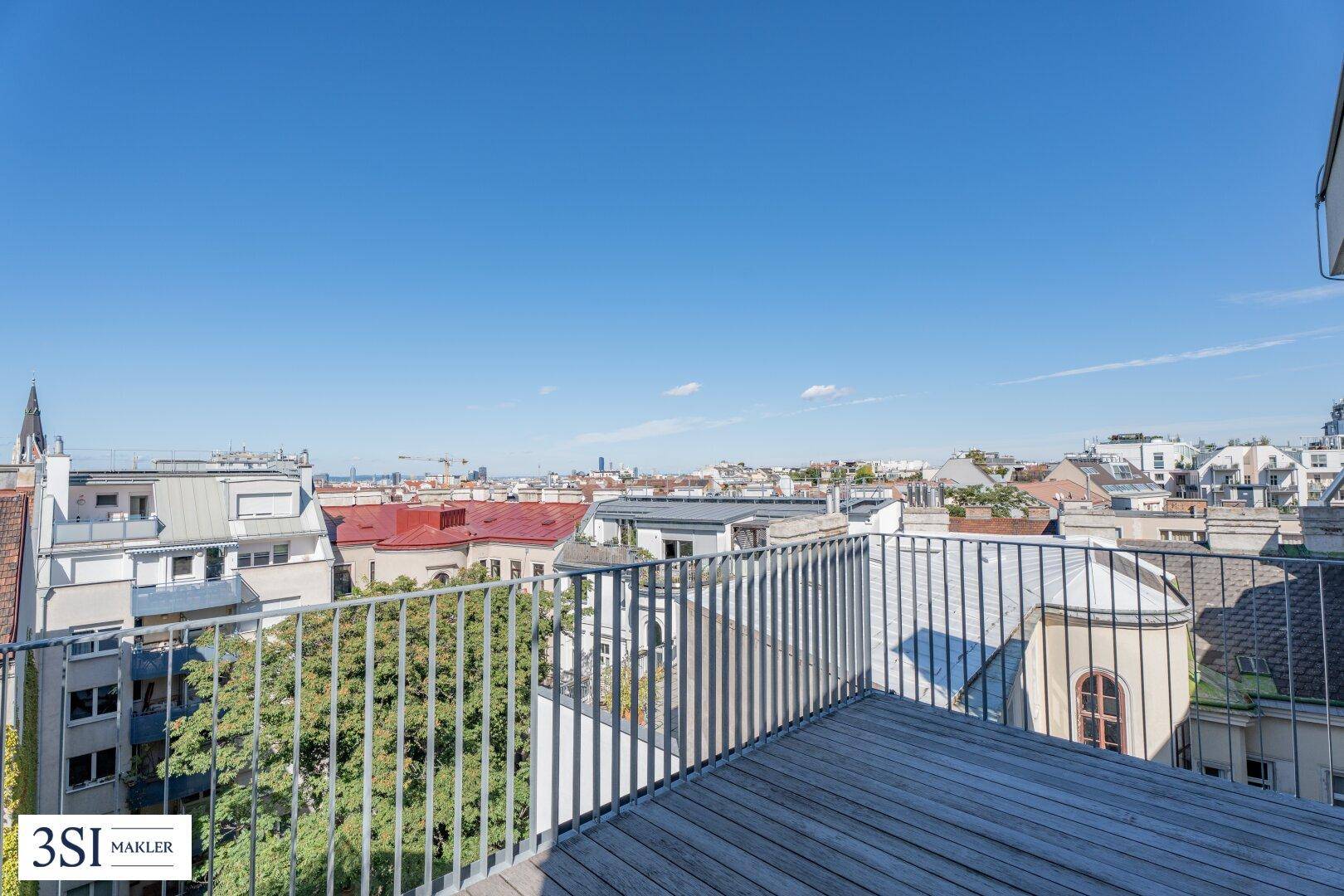 Terrasse mit weitem Blick über die Stadt, umgeben von Dächern und urbaner Architektur.