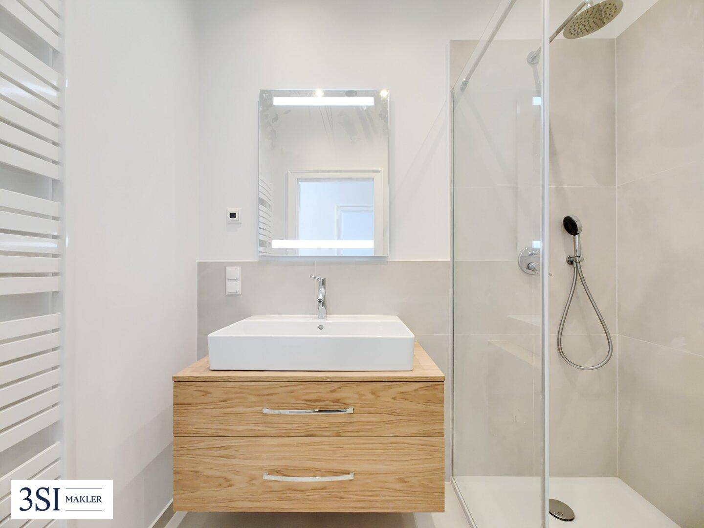 Modernes Badezimmer mit begehbarer Dusche, Regenbrause und stilvollem Waschtisch.