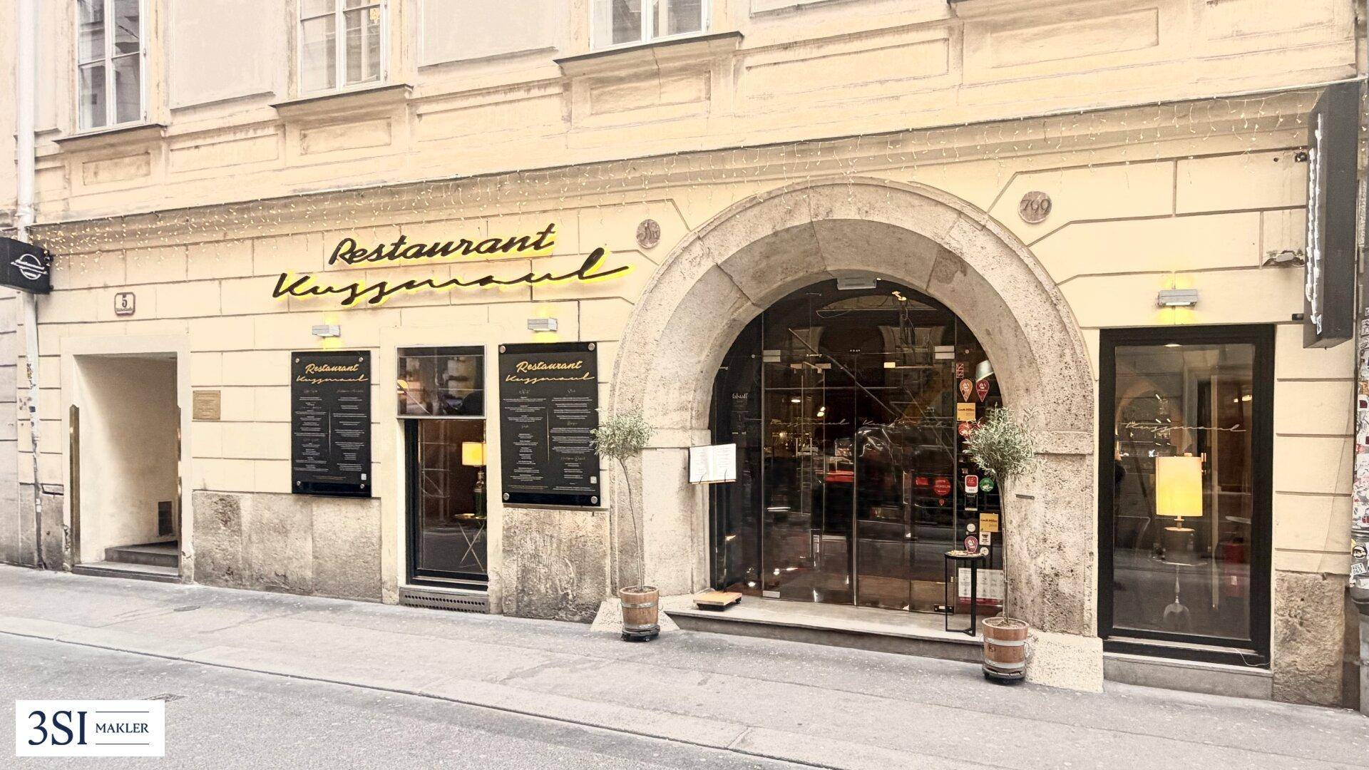 Ansicht der Restaurantfassade mit beleuchtetem Eingangsbereich und historischen Details.