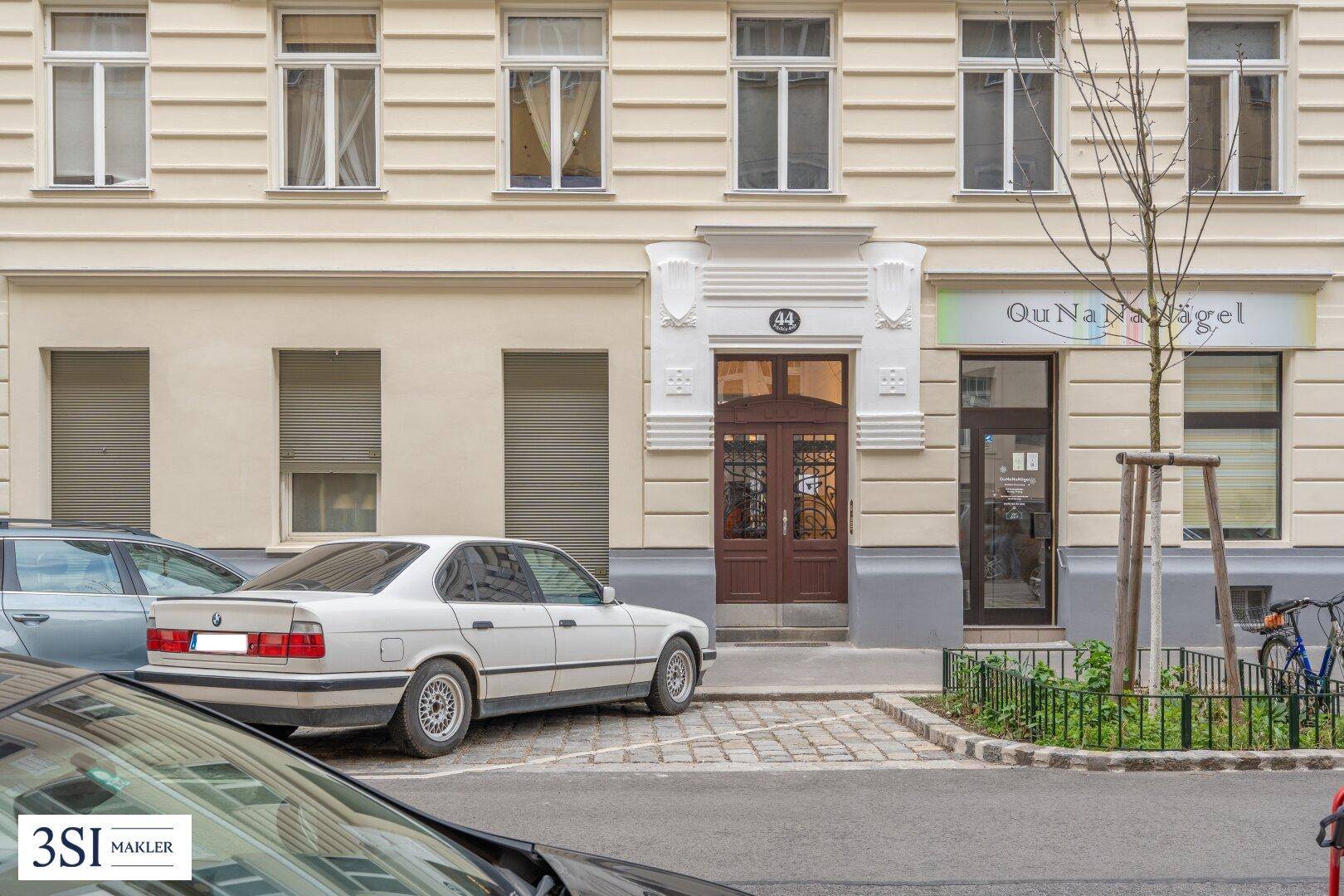 Detailansicht des Haupteingangs mit kunstvoller Holztür und dekorativen Elementen an der Fassade.