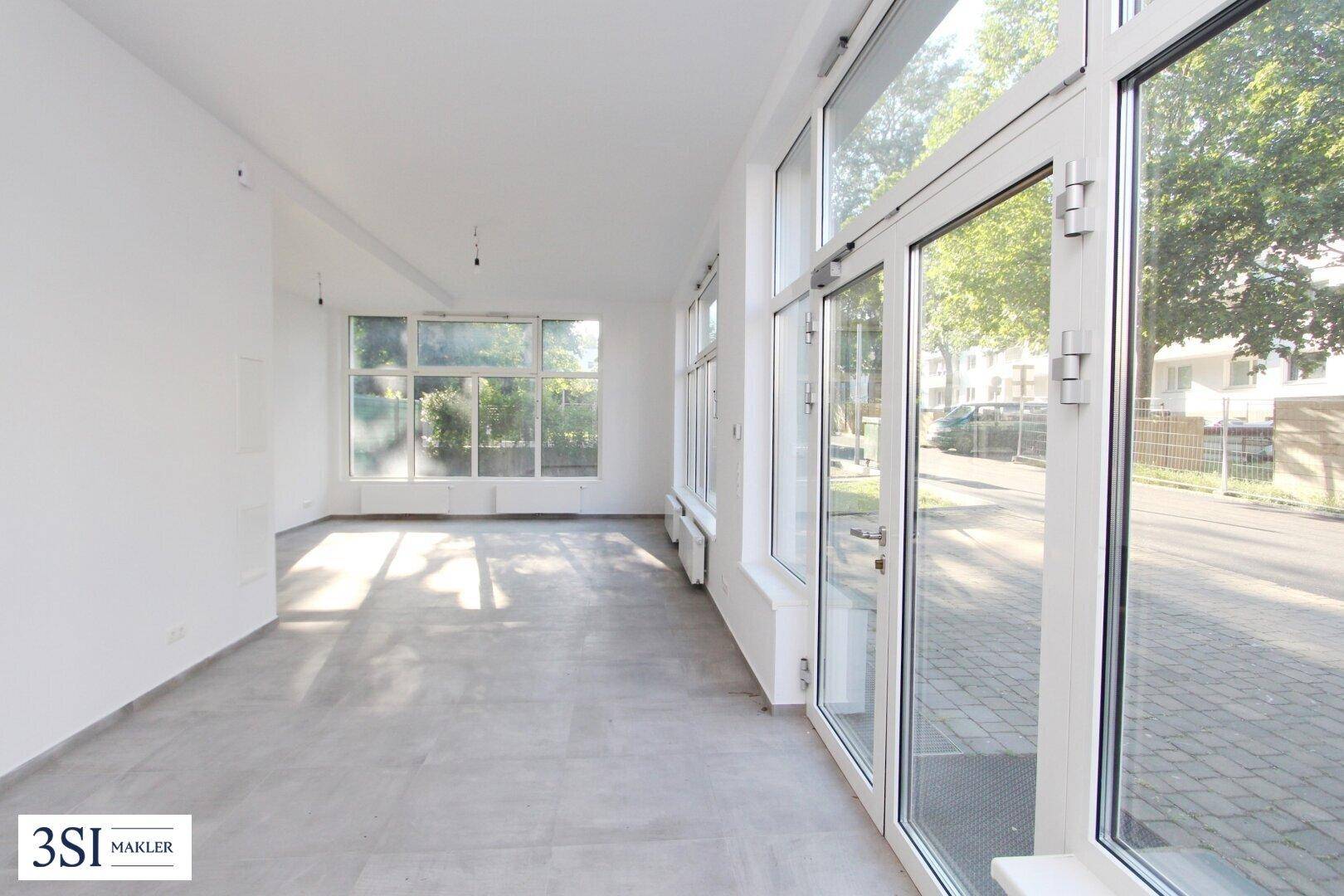 Geräumiger, heller Raum mit großen Fenstern und Zugang zur Straße, ideal für vielfältige Nutzung.