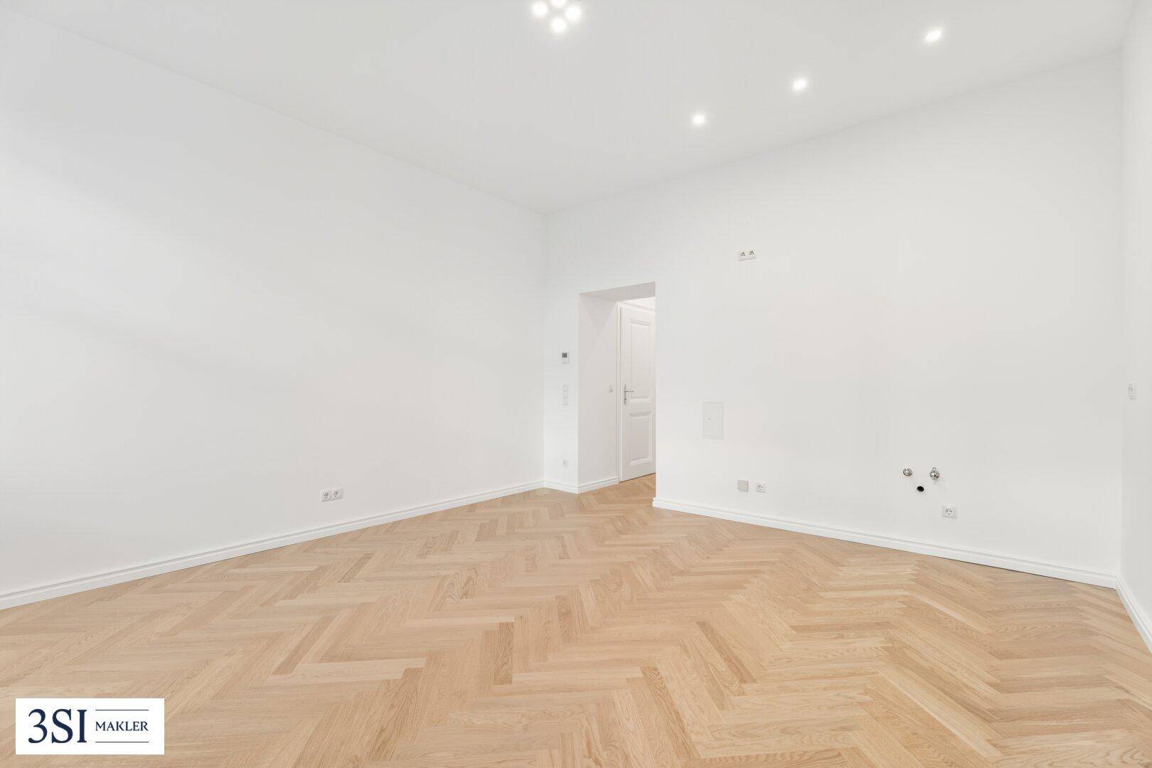 Modern renovierter Raum mit Fischgrätparkett und Einbaustrahlern, ideal für vielseitige Nutzung.