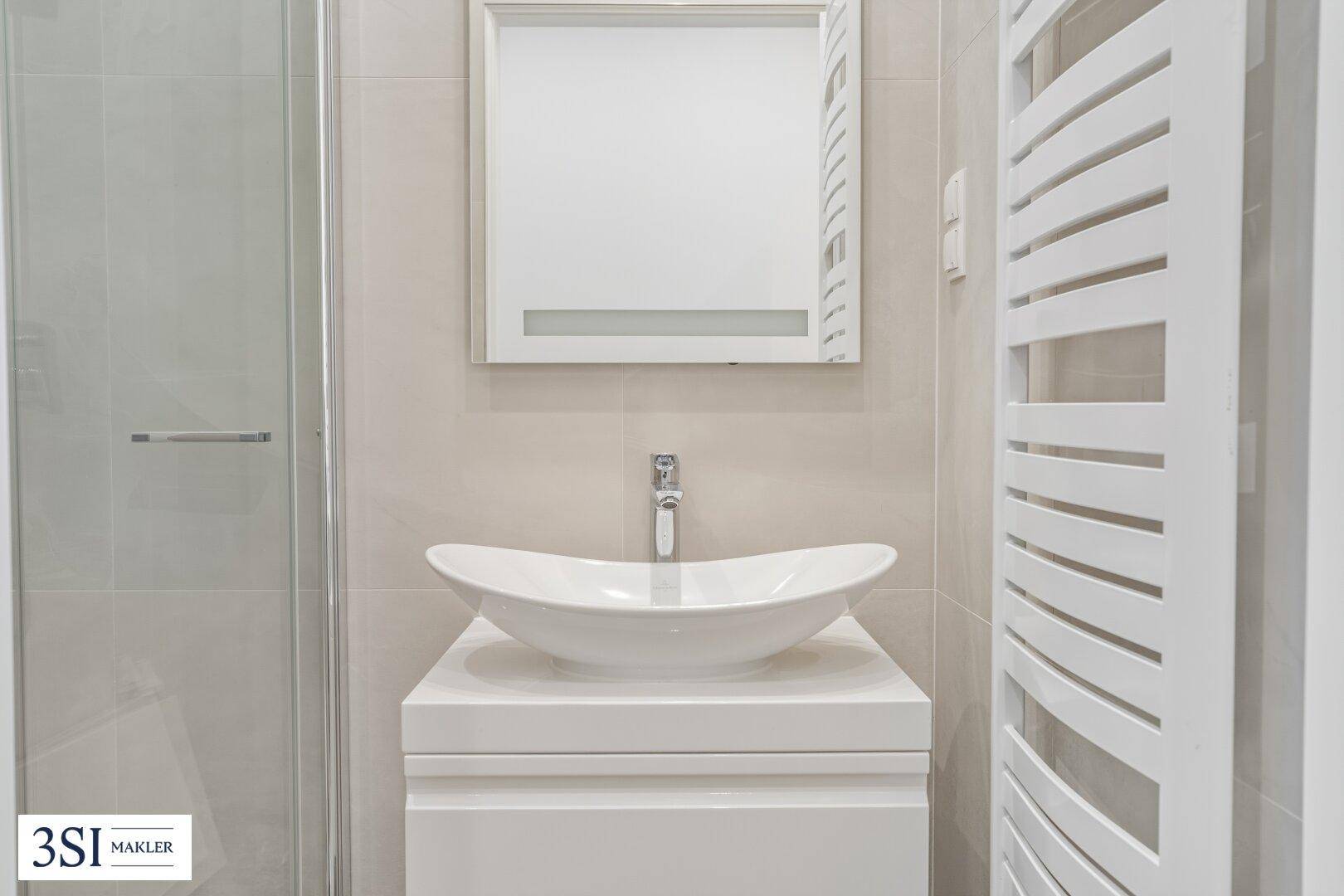 Modernes Badezimmer mit stilvollem Aufsatzwaschbecken, Duschkabine und beheiztem Handtuchhalter.