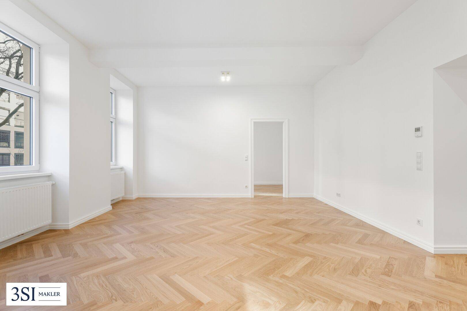 Heller, leerer Raum mit Fischgrätparkett und hohen Decken, bietet viel Gestaltungspotenzial.