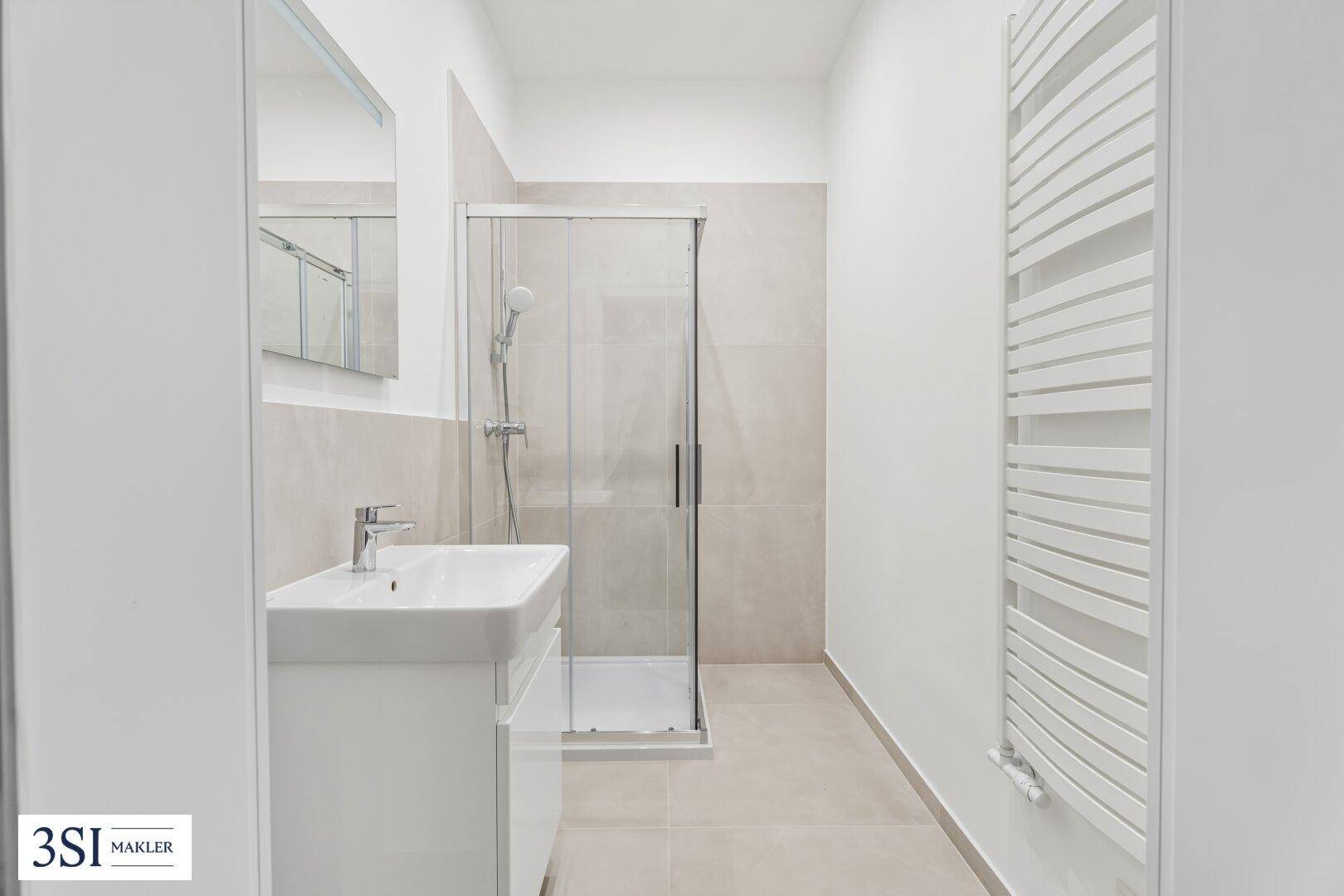 Modernes Badezimmer mit begehbarer Dusche, Einzelwaschbecken und beheiztem Handtuchhalter.