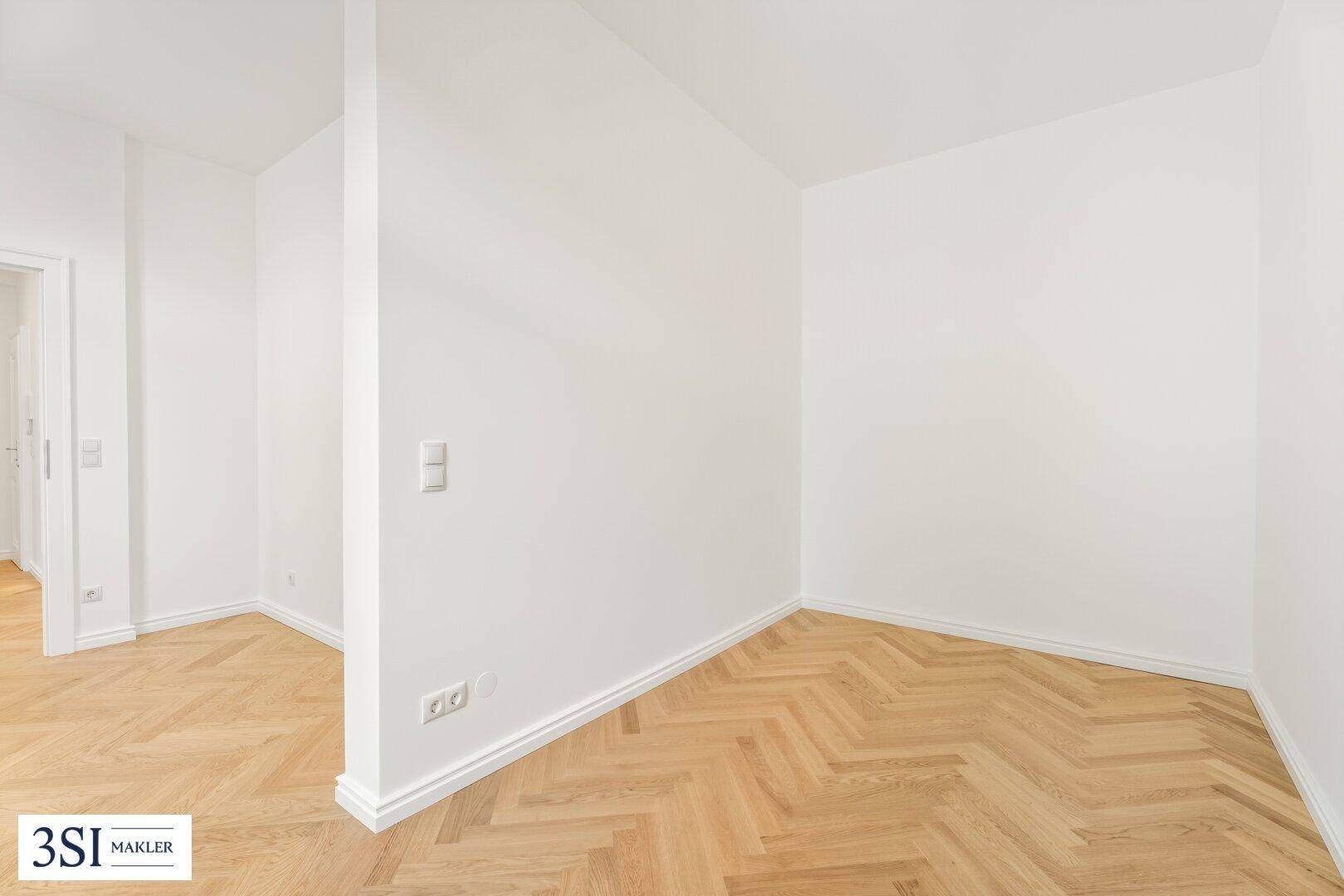 Heller Raum mit Fischgrätparkett und weißen Wänden, der vielseitig genutzt werden kann.