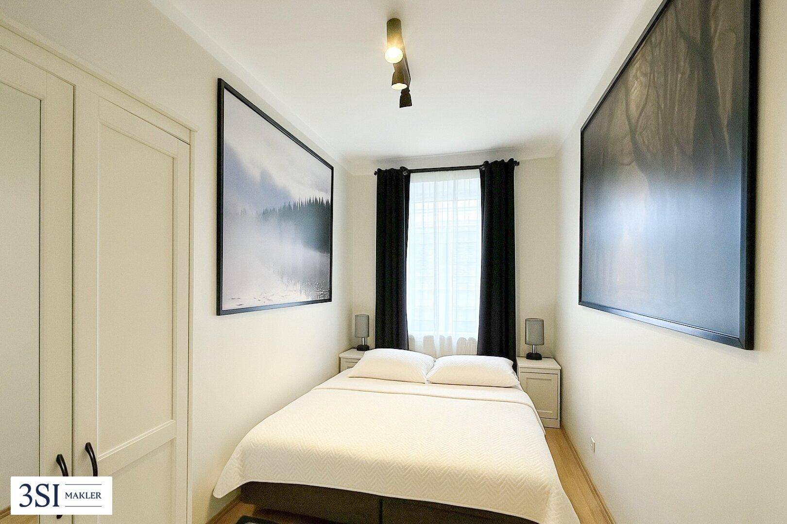 Gemütliches Schlafzimmer mit Doppelbett, Nachttischen und Holzboden.