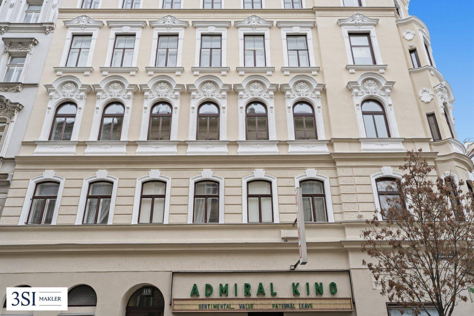 Nahaufnahme der historischen Fassade mit detaillierten Stuckelementen und klassischen Fenstern.