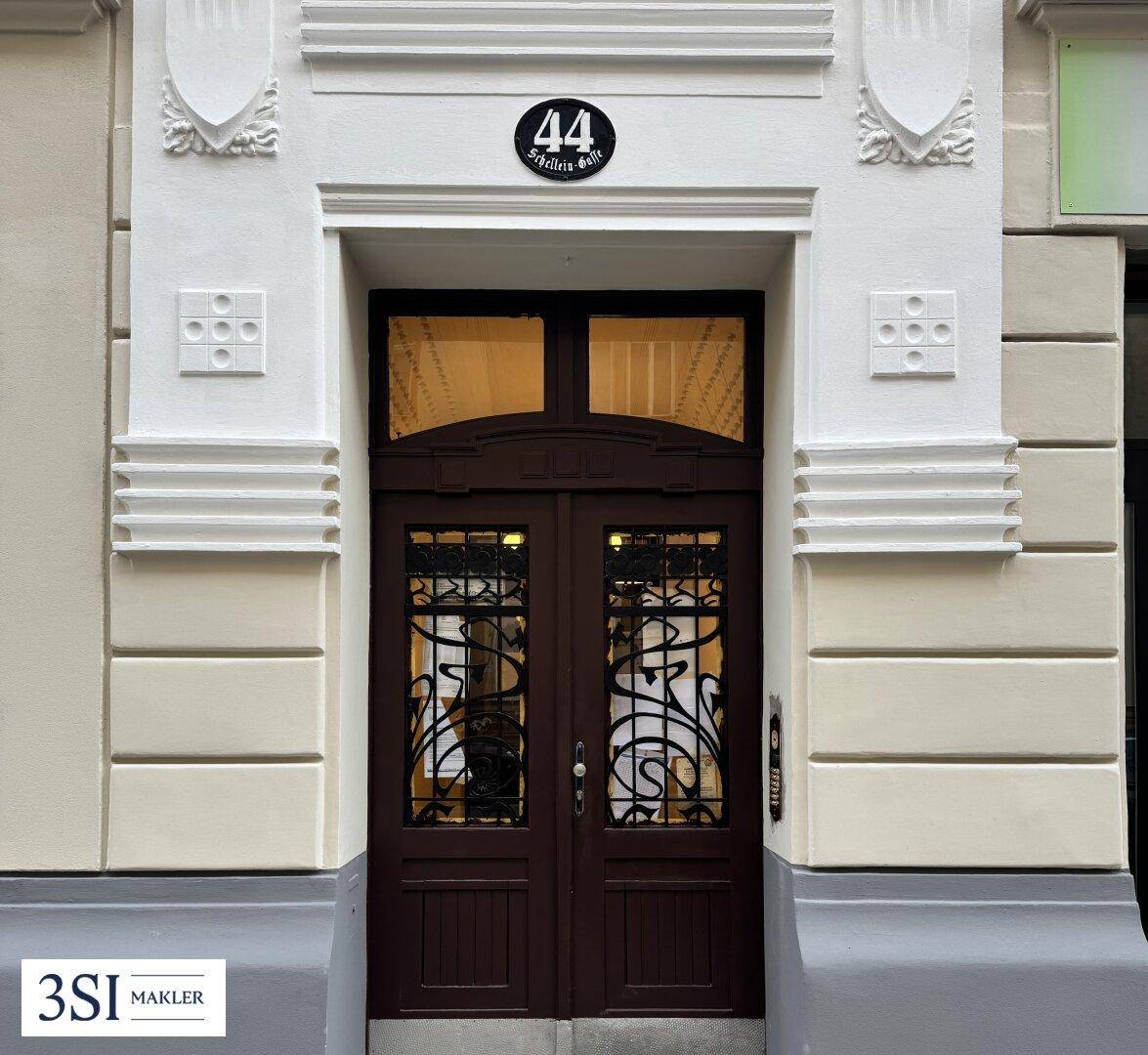 Nahaufnahme des historischen Hauseingangs mit der Nummer 44 und kunstvollen Verzierungen.