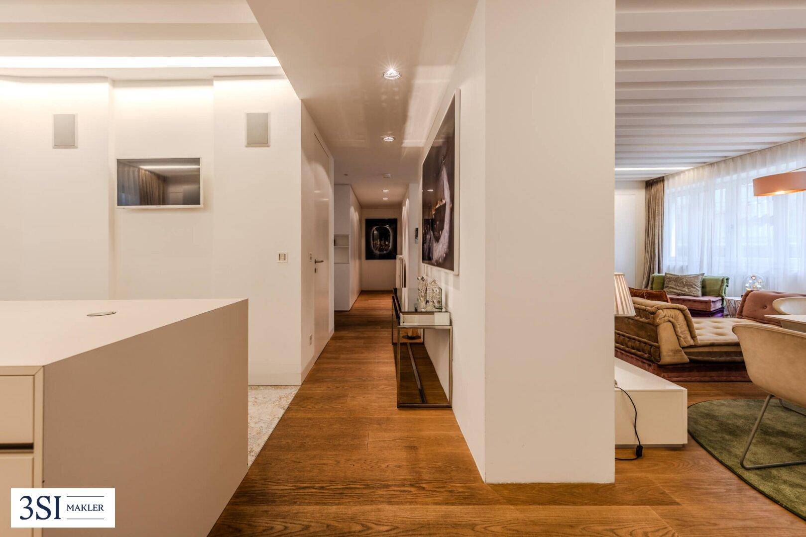 Heller Flur mit Holzboden, moderner Kunst und eleganten Spiegelelementen.