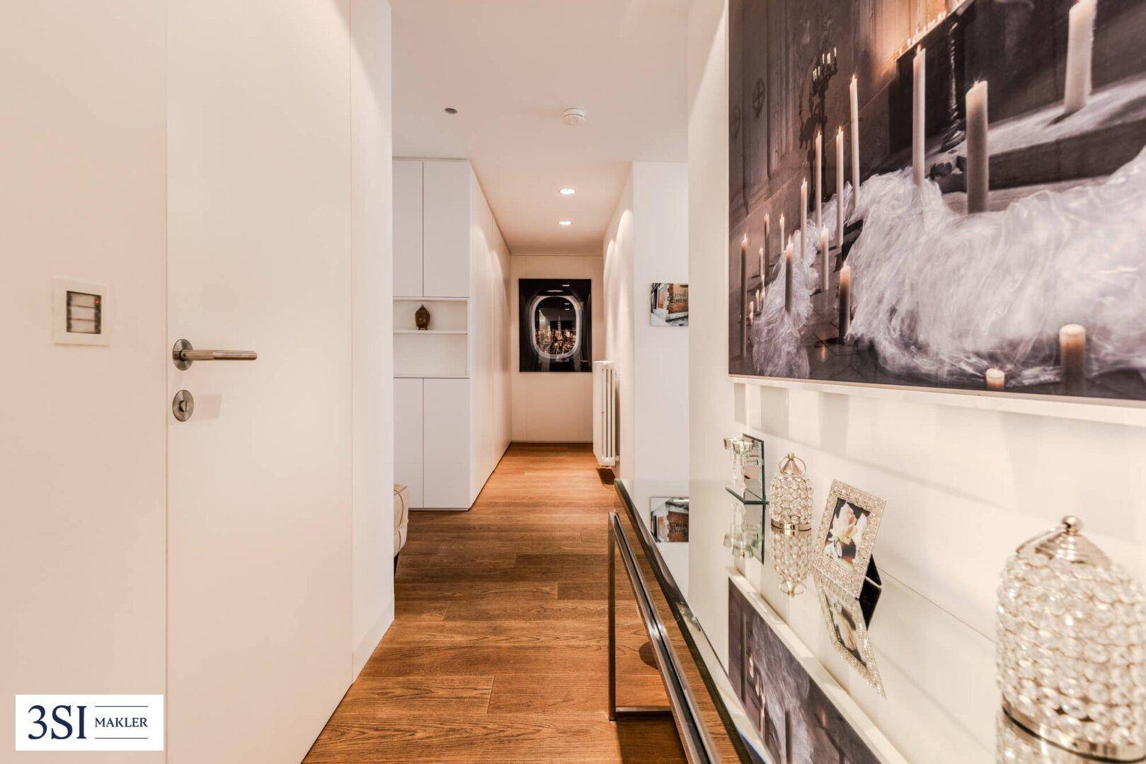 Langer, heller Flur mit Holzboden und moderner Wanddekoration.