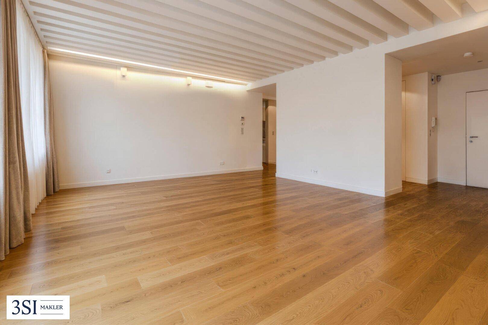 Geräumiger, leerer Raum mit Holzboden und hohen Decken, ideal für individuelle Gestaltung.