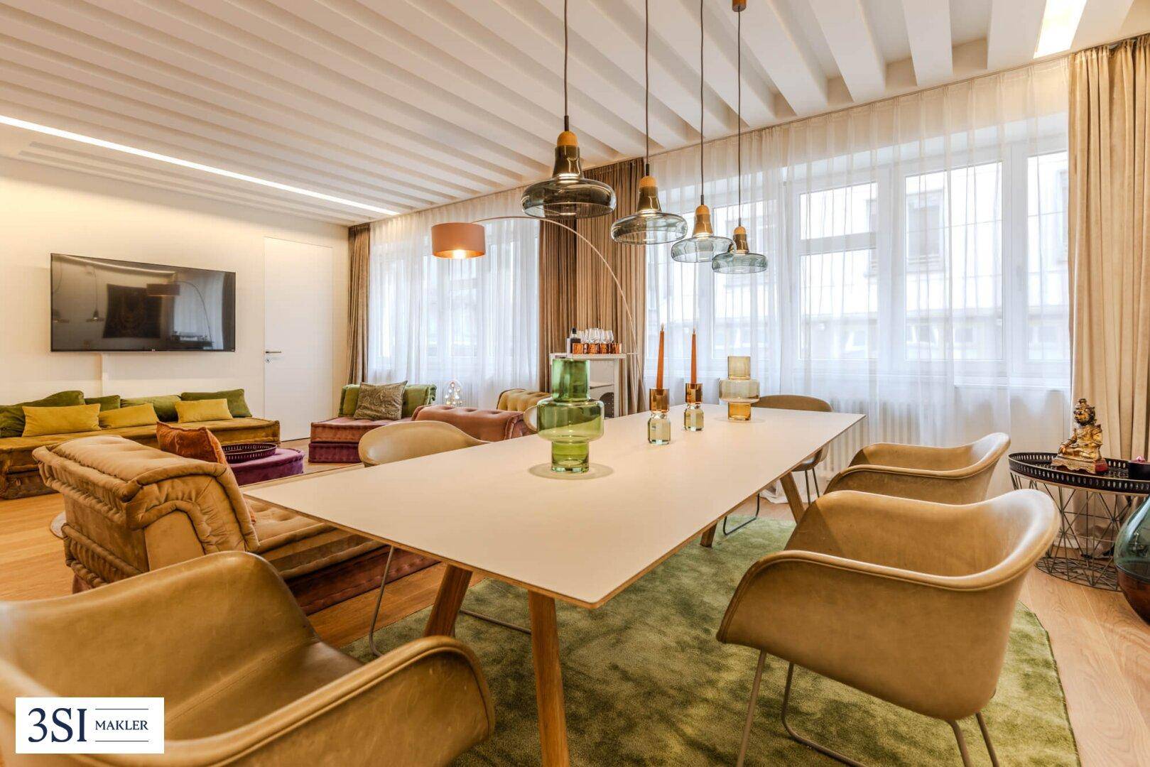 Heller Wohn- und Essbereich mit elegantem Esstisch, Pendelleuchten und Blick nach draußen.