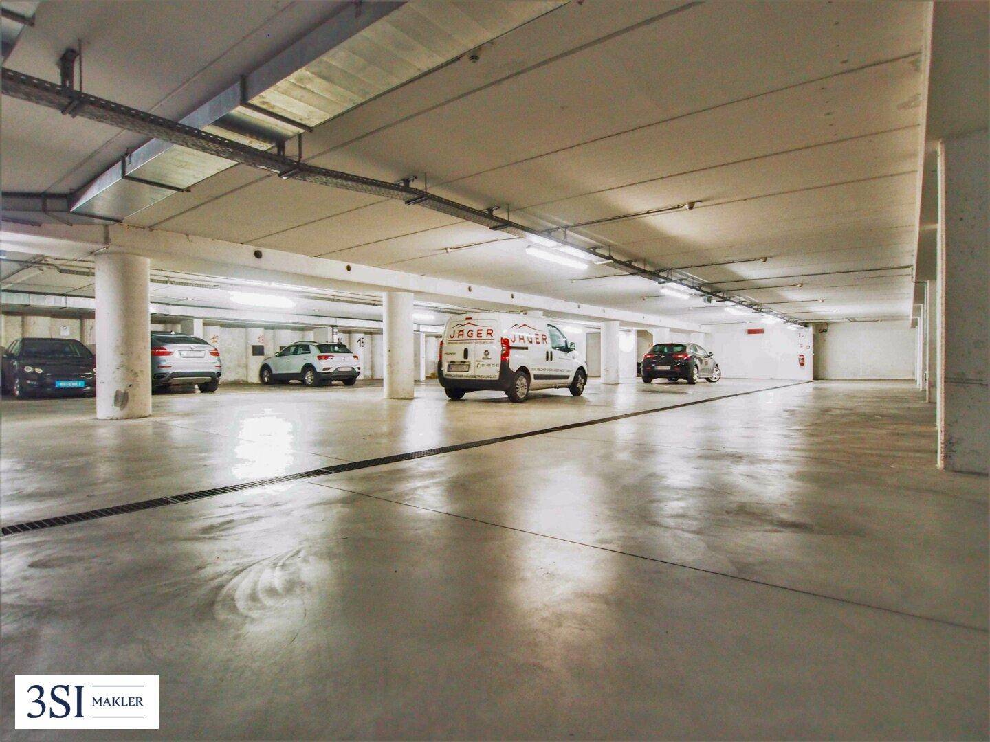 Saubere und gut beleuchtete Tiefgarage mit ausreichend Platz für mehrere Fahrzeuge.