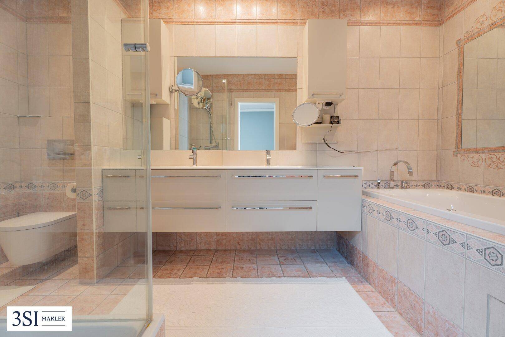 Geräumiges Badezimmer mit Doppelwaschbecken, Badewanne und separater Duschkabine.