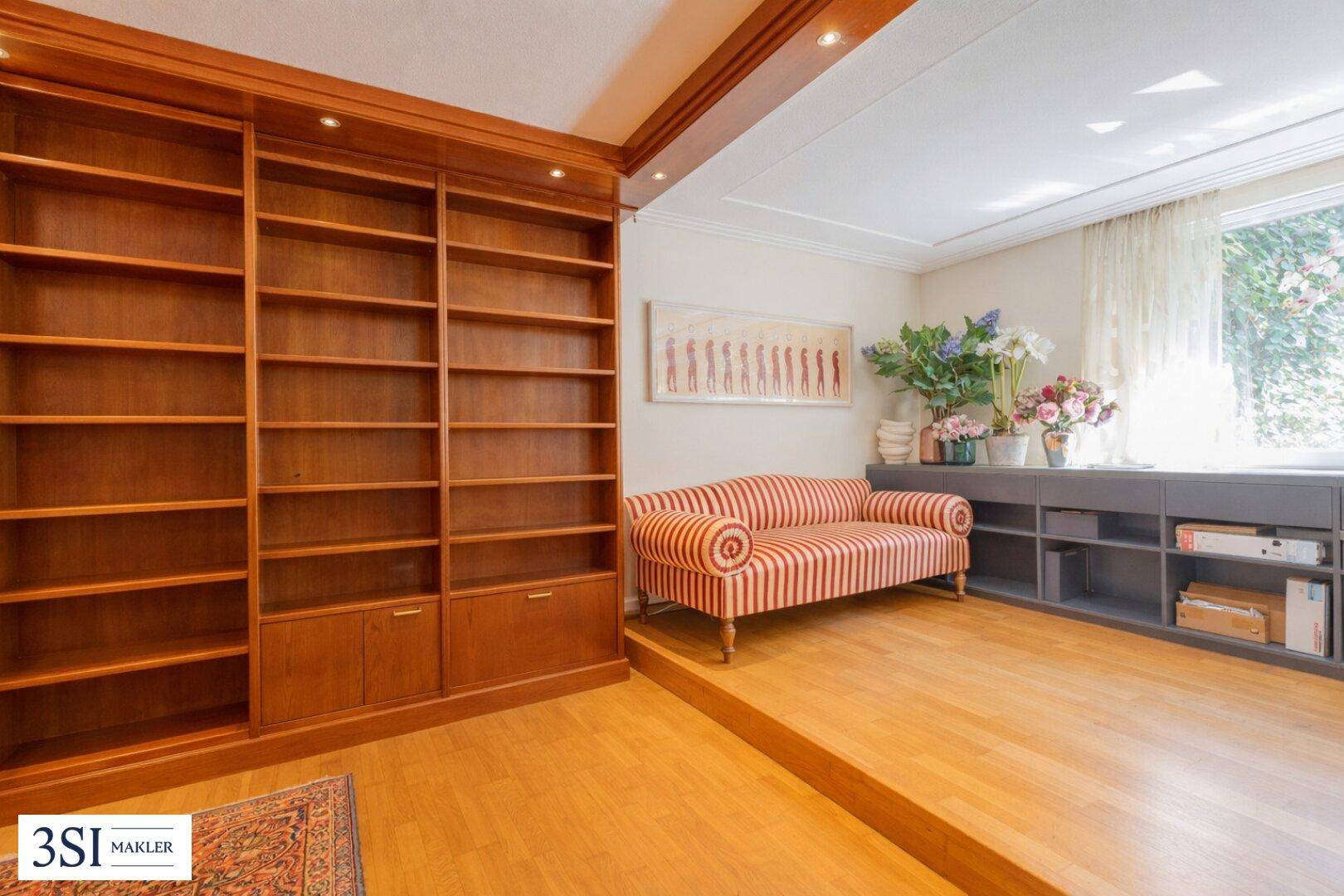 Gemütlicher Raum mit großen, eingebauten Holzregalen und einem gestreiften Sofa.
