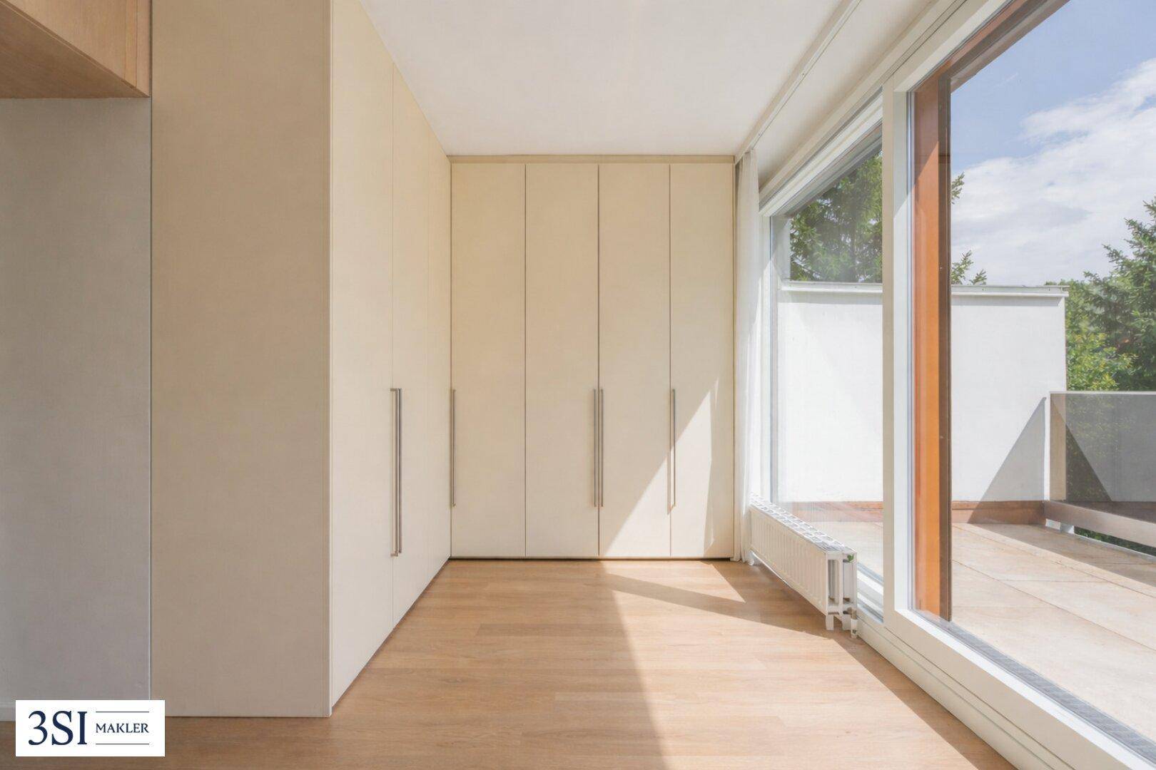 Helles Schlafzimmer mit Einbauschränken und Zugang zu einer sonnigen Terrasse.