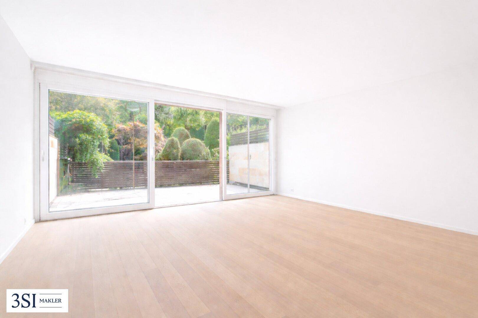 Heller, leerer Raum mit großen Schiebetüren, die den Blick in den grünen Garten freigeben.