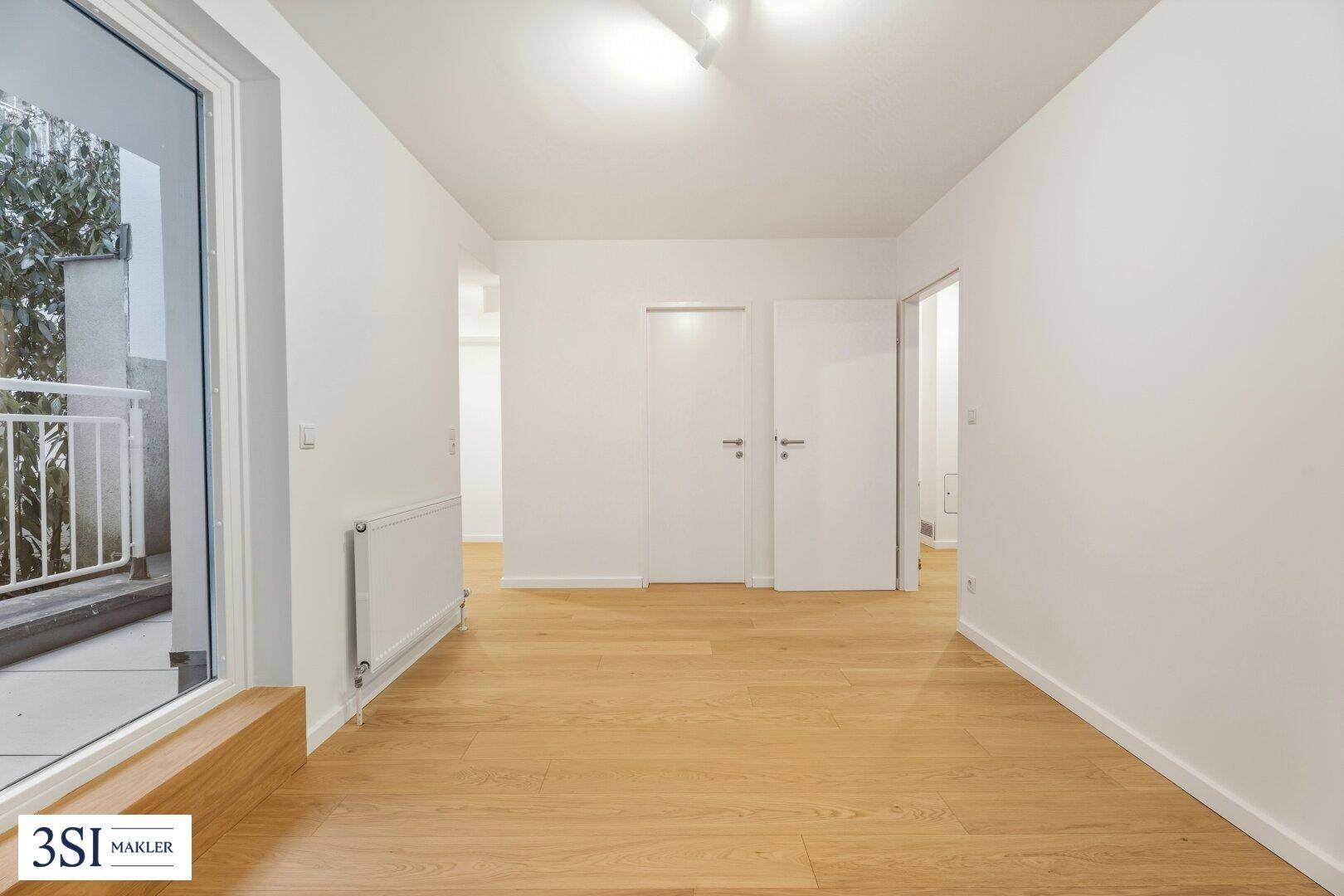 Geräumiger, heller Raum mit Parkettboden und direktem Zugang zum Außenbereich.