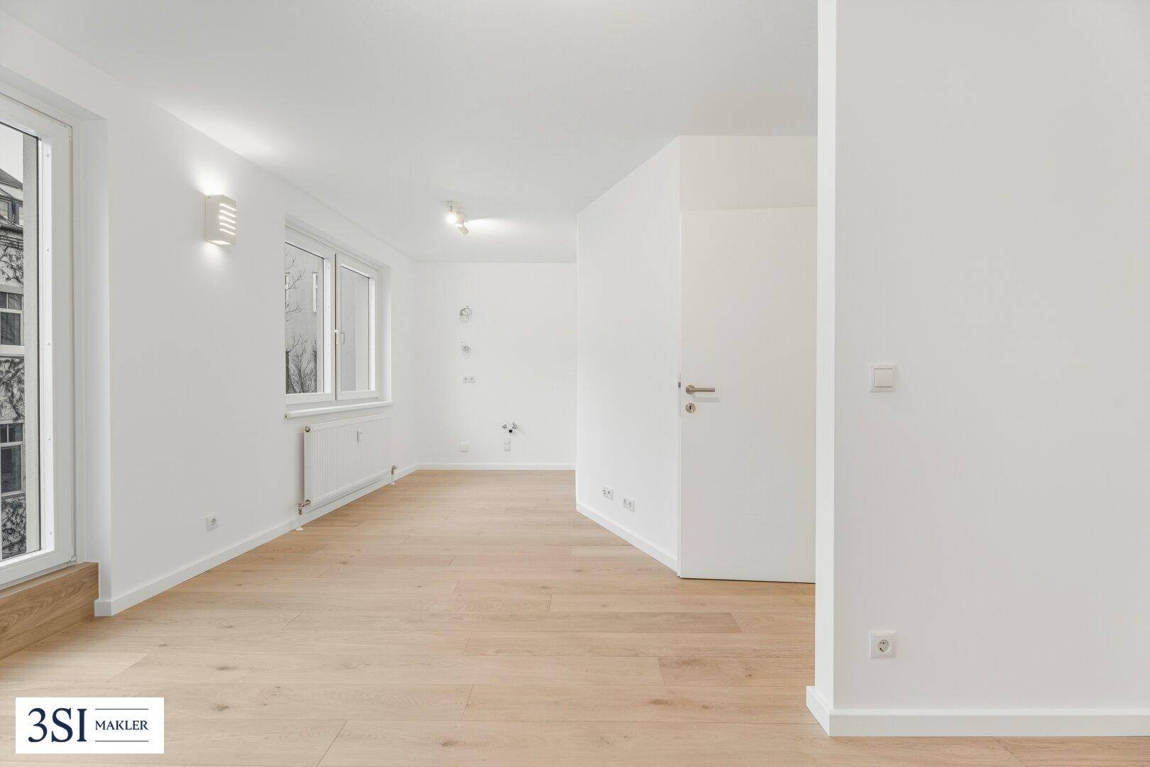 Lichtdurchfluteter Wohnbereich mit hellem Parkettboden und modernen Wandleuchten.