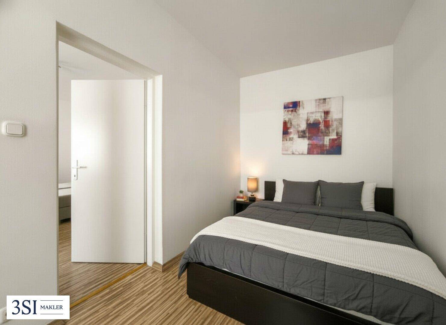 Ruhiges Schlafzimmer mit Doppelbett, Nachttischen und Holzboden.