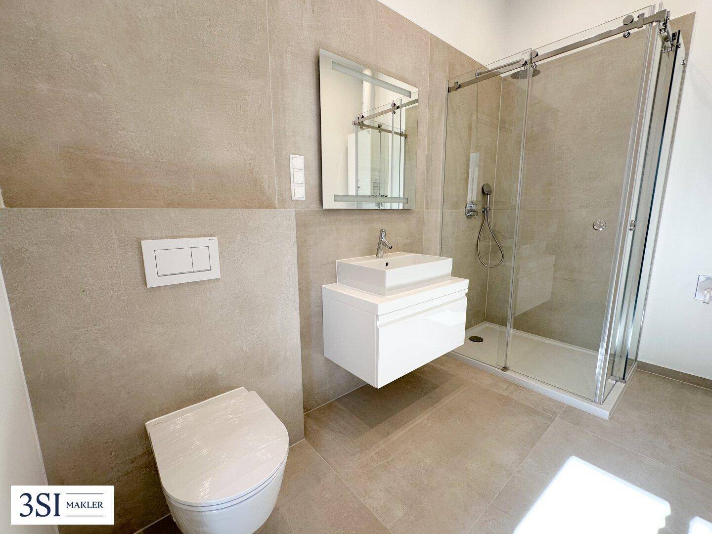 Zeitgemäßes Badezimmer mit ebenerdiger Dusche, wandhängendem WC und modernem Einzelwaschbecken.