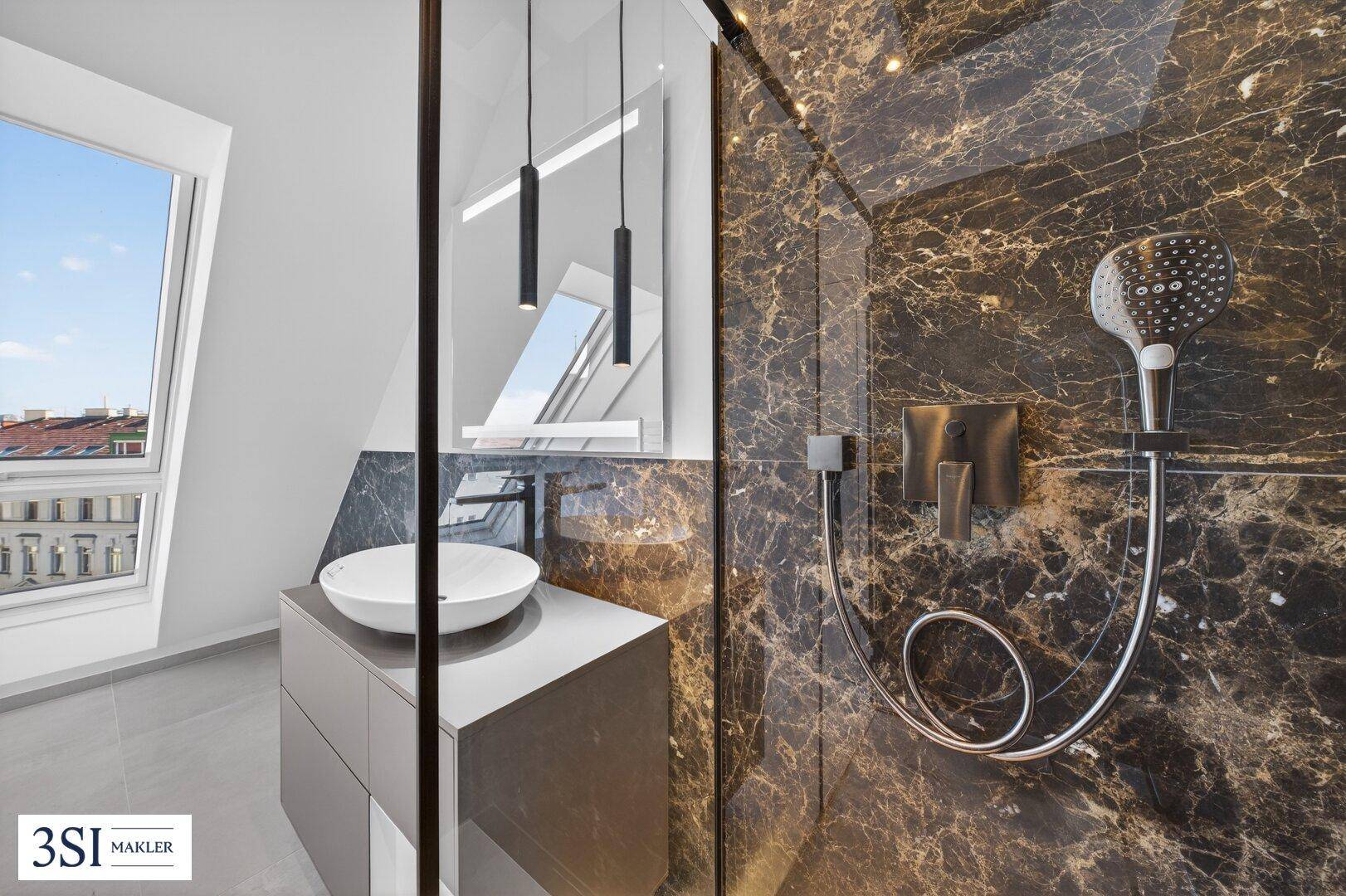 Modernes Badezimmer mit dunklen Marmorfliesen, begehbarer Dusche und elegantem Waschbecken mit Fenster.